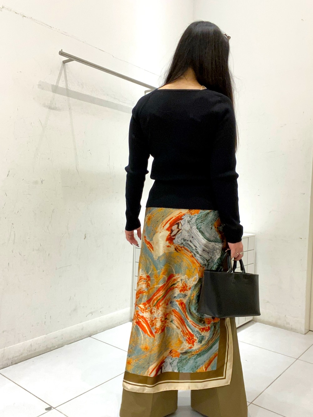 ブラック系のニット/セーター、ベージュ系のその他パンツ、ブラック系のトートバッグを着用したレディースの冬コーディネートの3枚目の写真