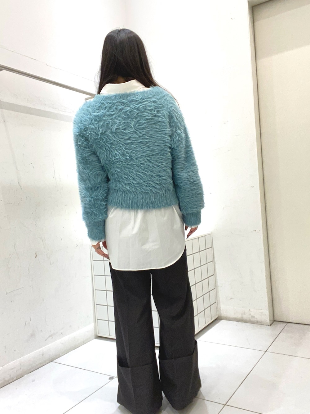 ブルー系のニット/セーター、ホワイト系のシャツ/ブラウス、ブラック系のその他パンツを着用したレディースの秋コーディネートの3枚目の写真