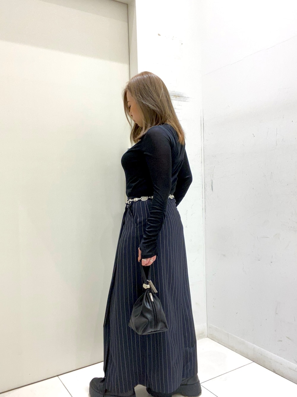 ブラック系のTシャツ/カットソー、ブルー系のスカート、ブラック系のハンドバッグを着用したレディースの春コーディネートの3枚目の写真