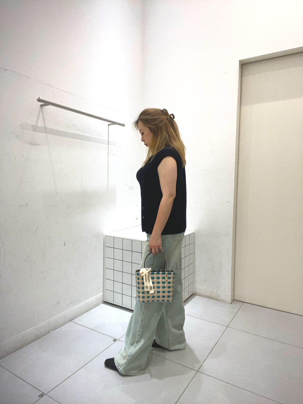 ブラック系のベスト、ブルー系のその他パンツ、グリーン系のショルダーバッグを着用したレディースの夏コーディネートの2枚目の写真
