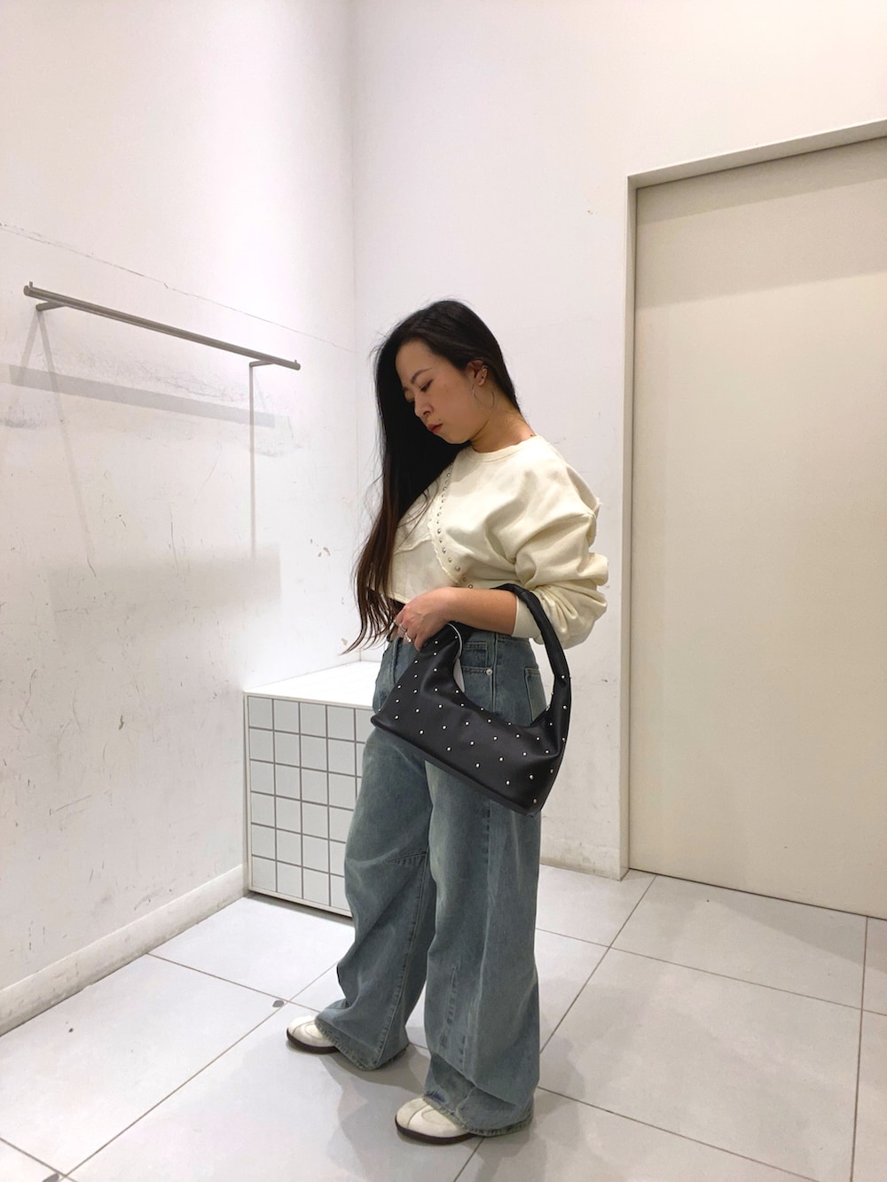 ホワイト系のスウェット、ブルー系のデニムパンツ、ブルー系のデニムパンツを着用したレディースの冬コーディネートの3枚目の写真