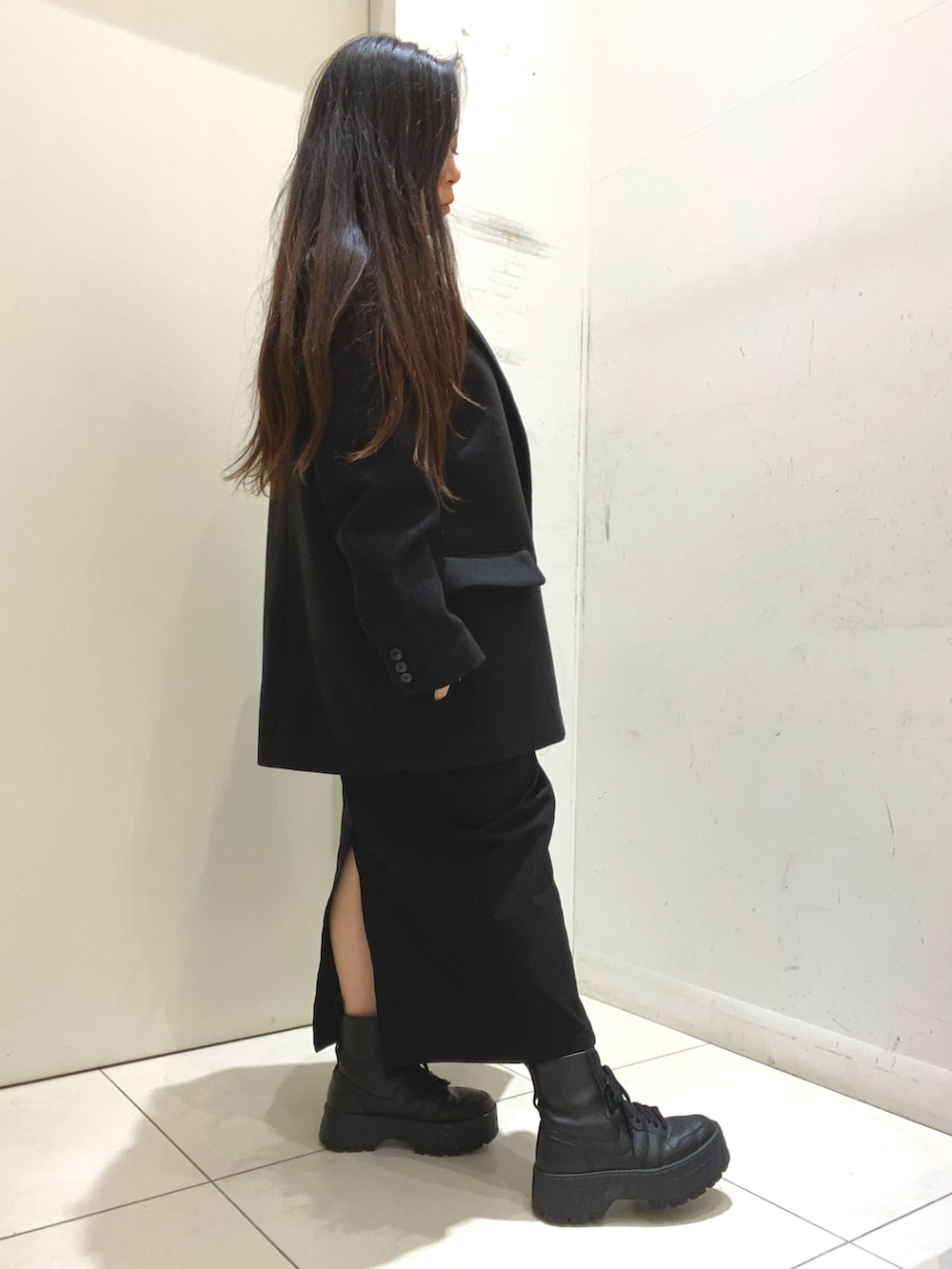 ブルー系のニット/セーター、ブラック系のスカート、ブラック系のその他アウターを着用したレディースの冬コーディネートの2枚目の写真