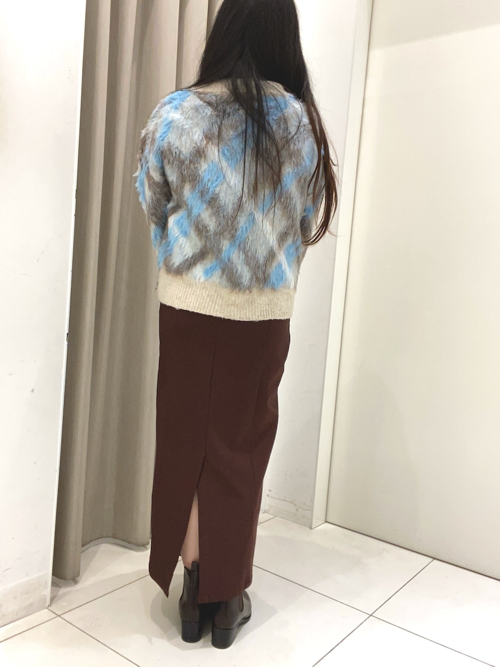 ブルー系のニット/セーター、ブルー系のカーディガン/ボレロ、ブラウン系のスカートを着用したレディースの冬コーディネートの4枚目の写真