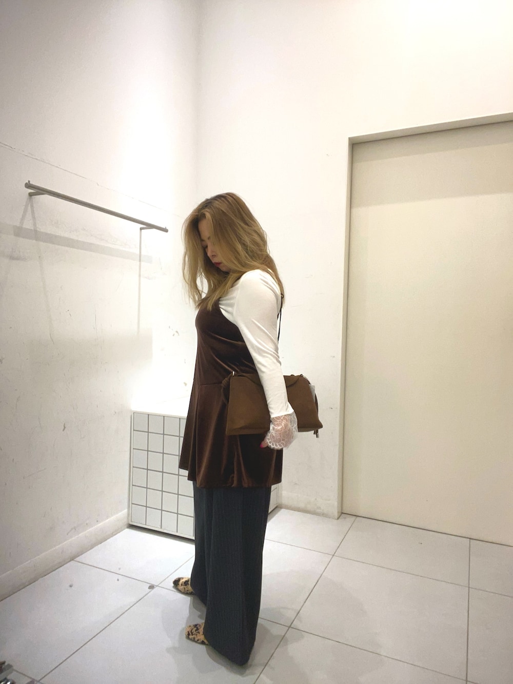 グレー系のその他パンツ、ブラウン系のチュニック、ホワイト系のTシャツ/カットソーを着用したレディースの秋コーディネートの2枚目の写真