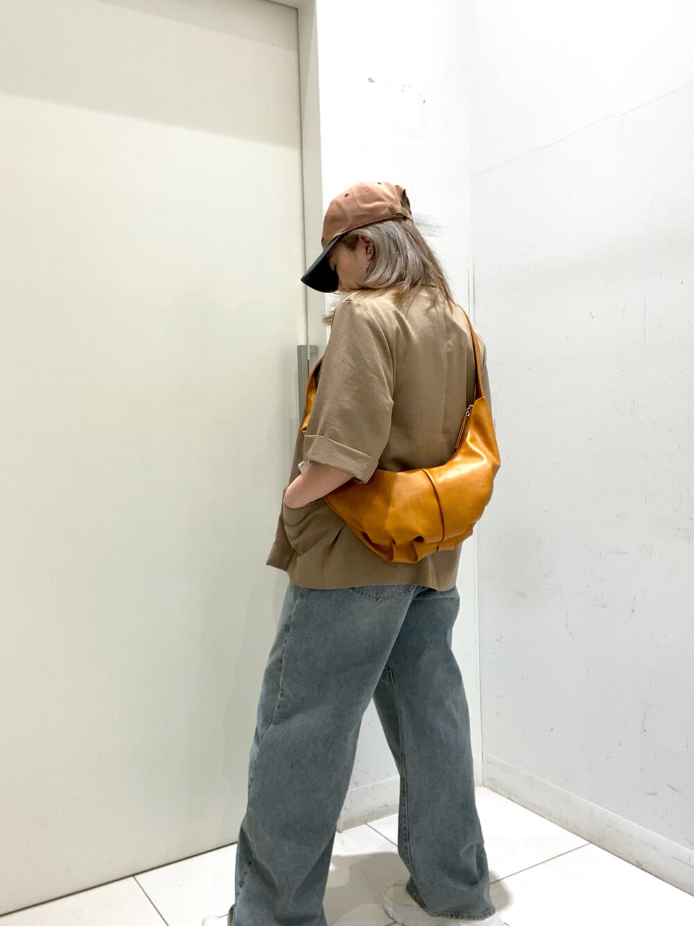 ベージュ系のその他アウター、イエロー系のショルダーバッグ、その他のTシャツ/カットソーを着用したレディースの春コーディネートの2枚目の写真