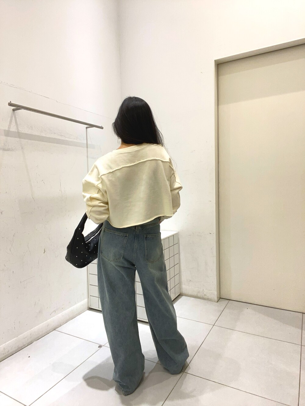 ホワイト系のスウェット、ブルー系のデニムパンツ、ブルー系のデニムパンツを着用したレディースの冬コーディネートの4枚目の写真