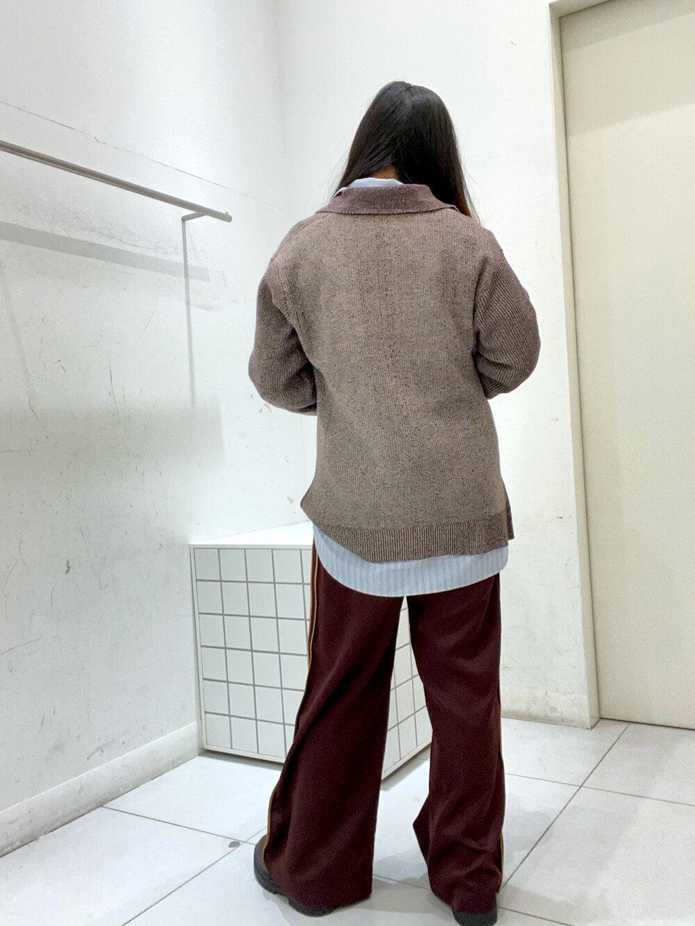 ブラウン系のニット/セーター、ブルー系のシャツ/ブラウス、ブラウン系のその他パンツを着用したレディースの秋コーディネートの3枚目の写真