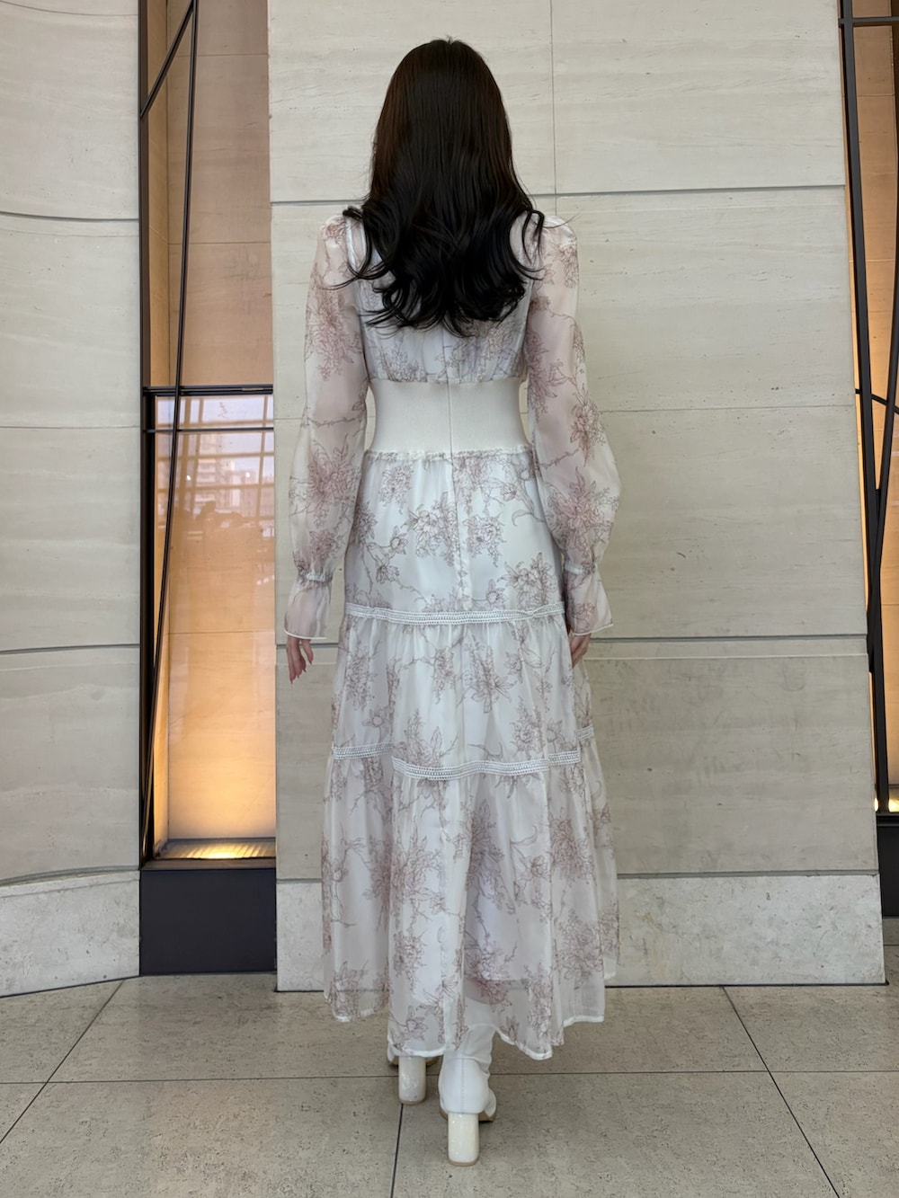 ベージュ系のワンピース、ホワイト系のブーツを着用したレディースの冬コーディネートの3枚目の写真