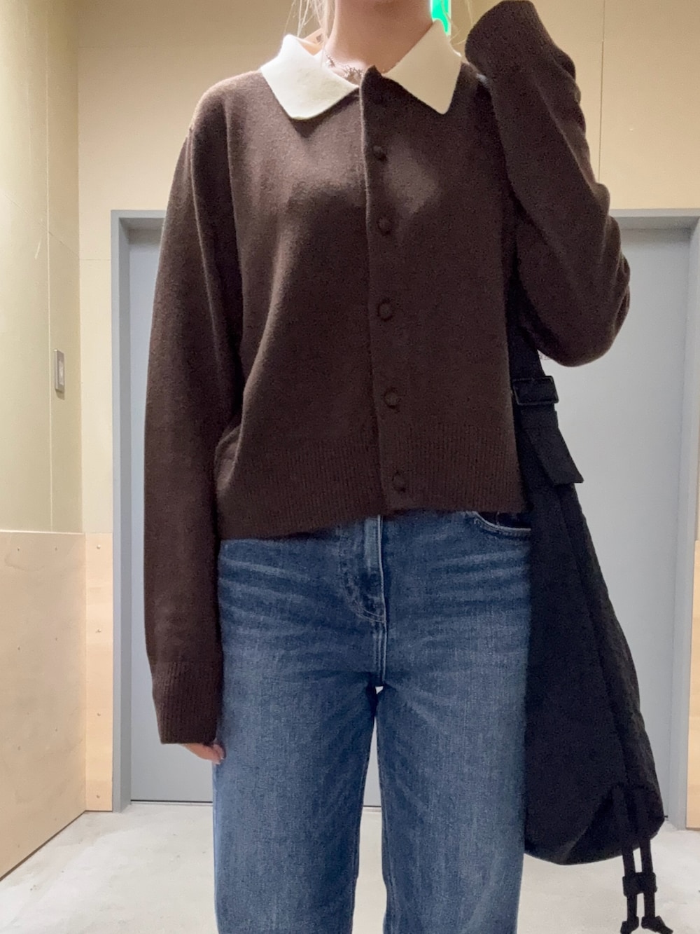 ブラウン系のニット/セーター、ブルー系のデニムパンツ、ブラック系のその他雑貨を着用したレディースの秋コーディネートの2枚目の写真