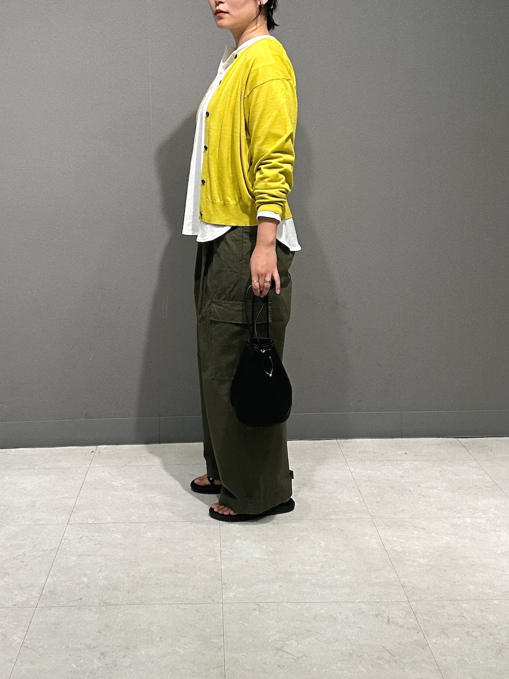 イエロー系のカーディガン/ボレロ、ホワイト系のTシャツ/カットソー、グリーン系のその他パンツを着用したレディースの夏コーディネートの3枚目の写真