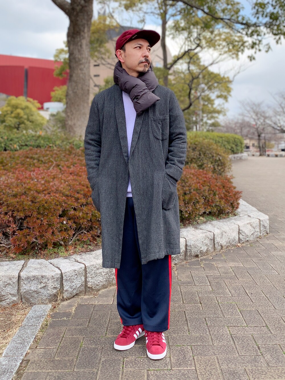 グレー系のその他アウター、ブルー系のその他パンツ、レッド系のスニーカーを着用したメンズの冬コーディネートの2枚目の写真