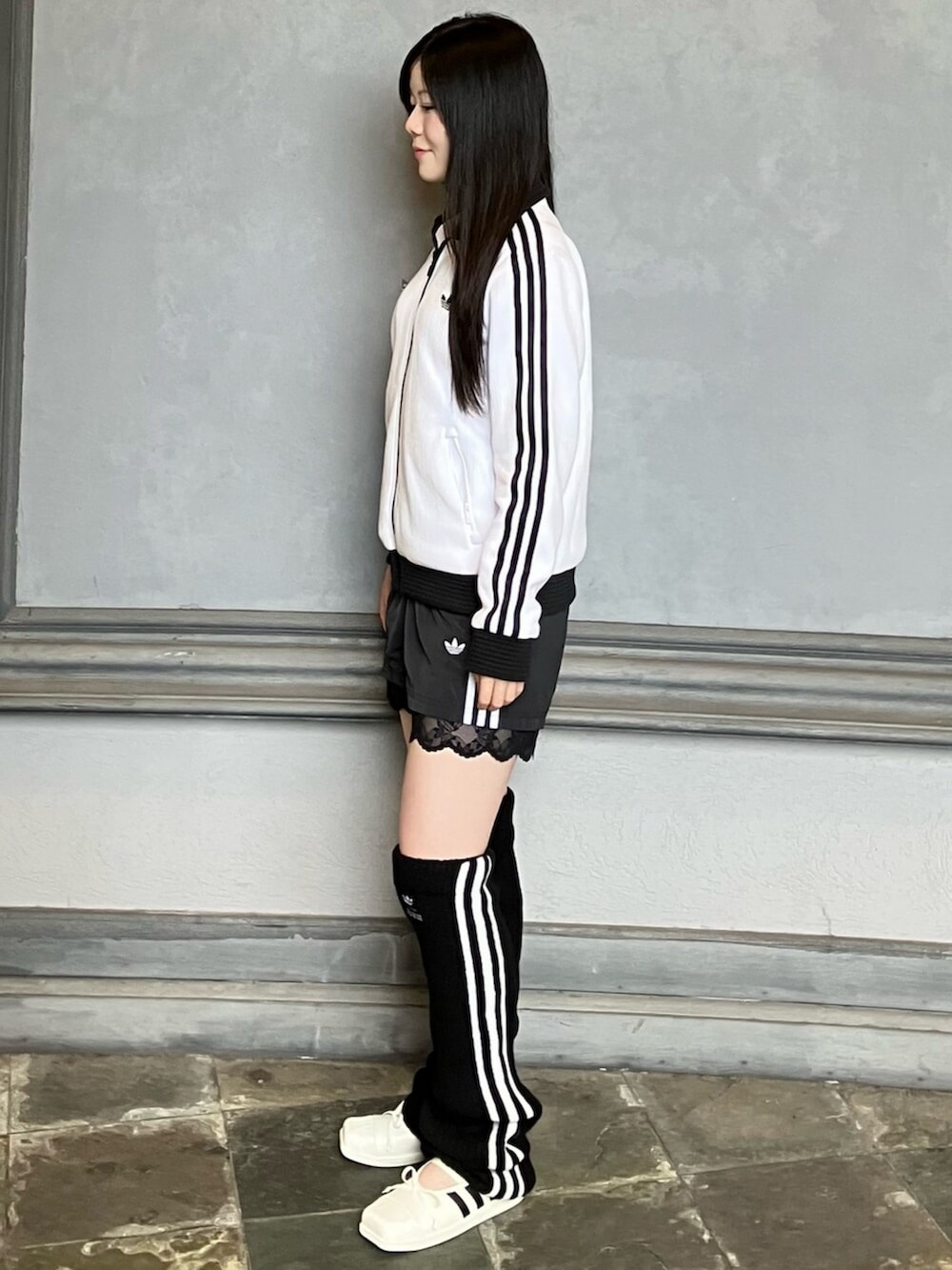 ホワイト系のジャージ、ブラック系のその他パンツ、ホワイト系のスニーカーを着用したレディースの秋コーディネートの2枚目の写真
