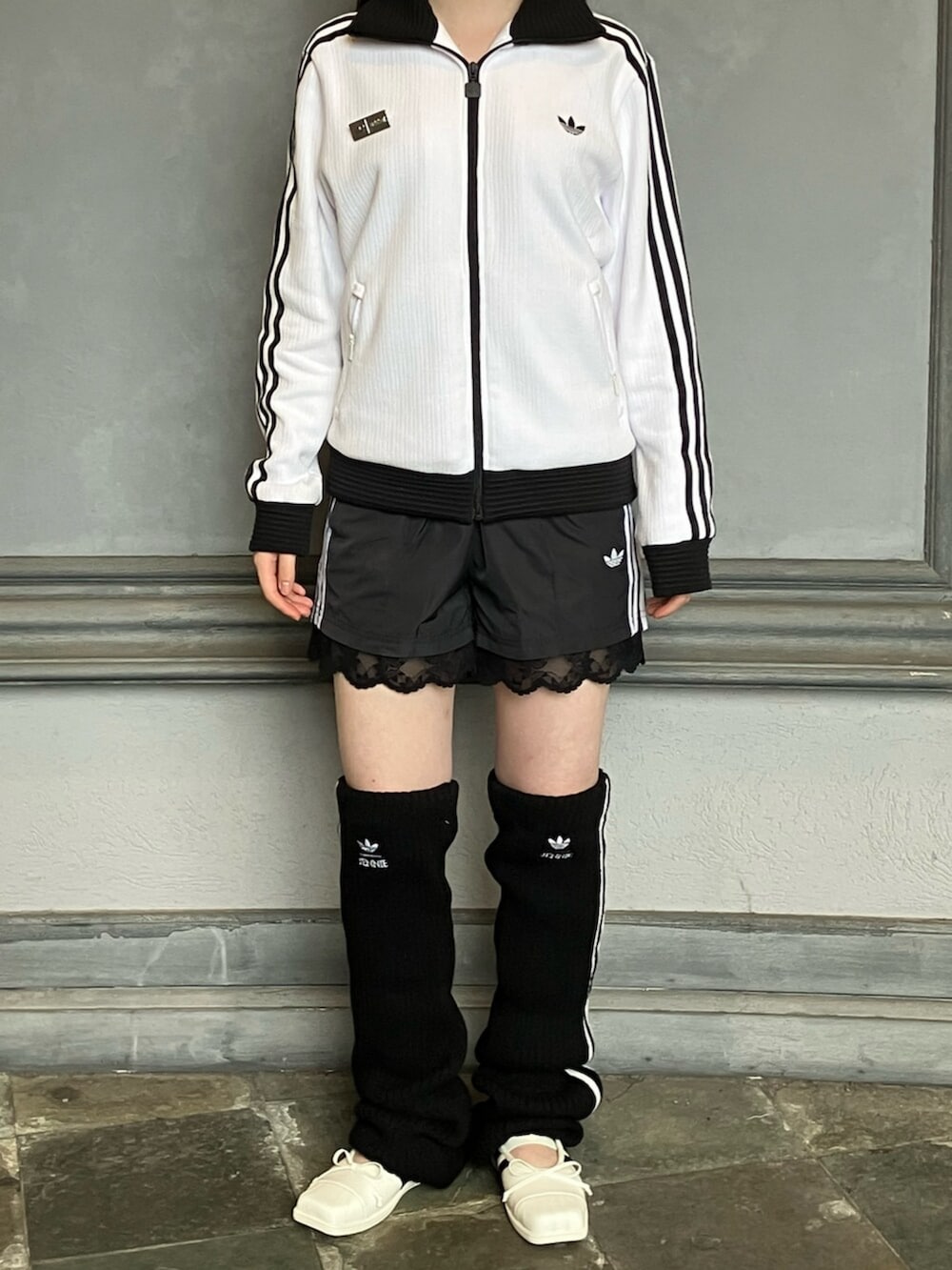ホワイト系のジャージ、ブラック系のその他パンツ、ホワイト系のスニーカーを着用したレディースの秋コーディネートの3枚目の写真