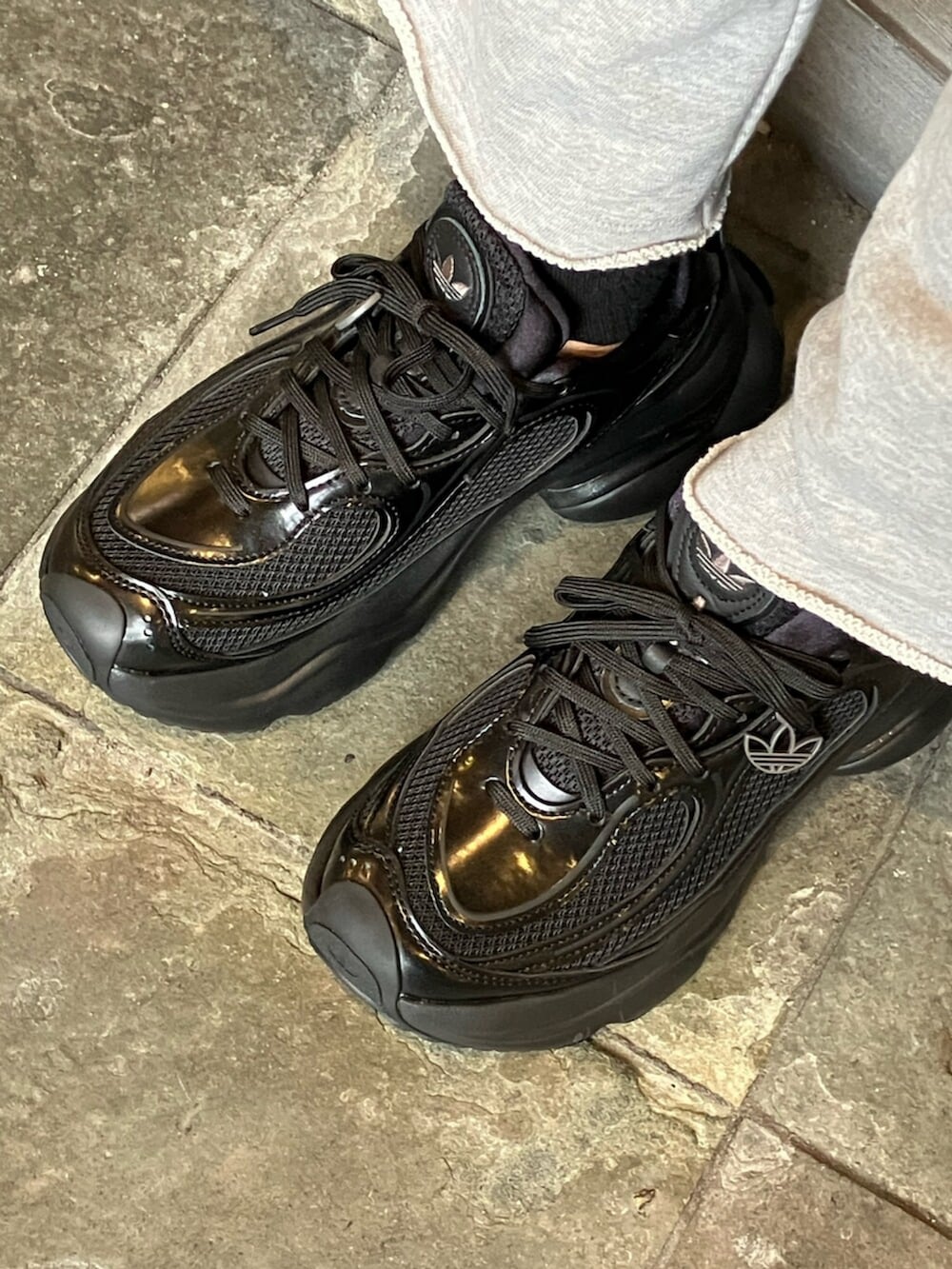 ホワイト系のジャージ、グレー系のパンツ、ブラック系のスニーカーを着用したレディースの秋コーディネートの4枚目の写真