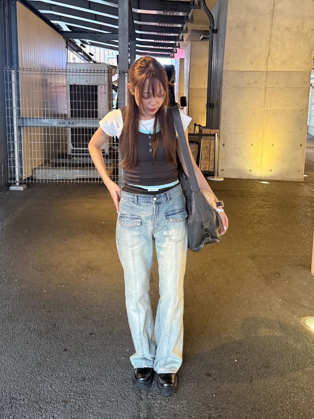 グレー系のタンクトップ、ブルー系のデニムパンツ、グレー系のショルダーバッグを着用したレディースの夏コーディネートの2枚目の写真