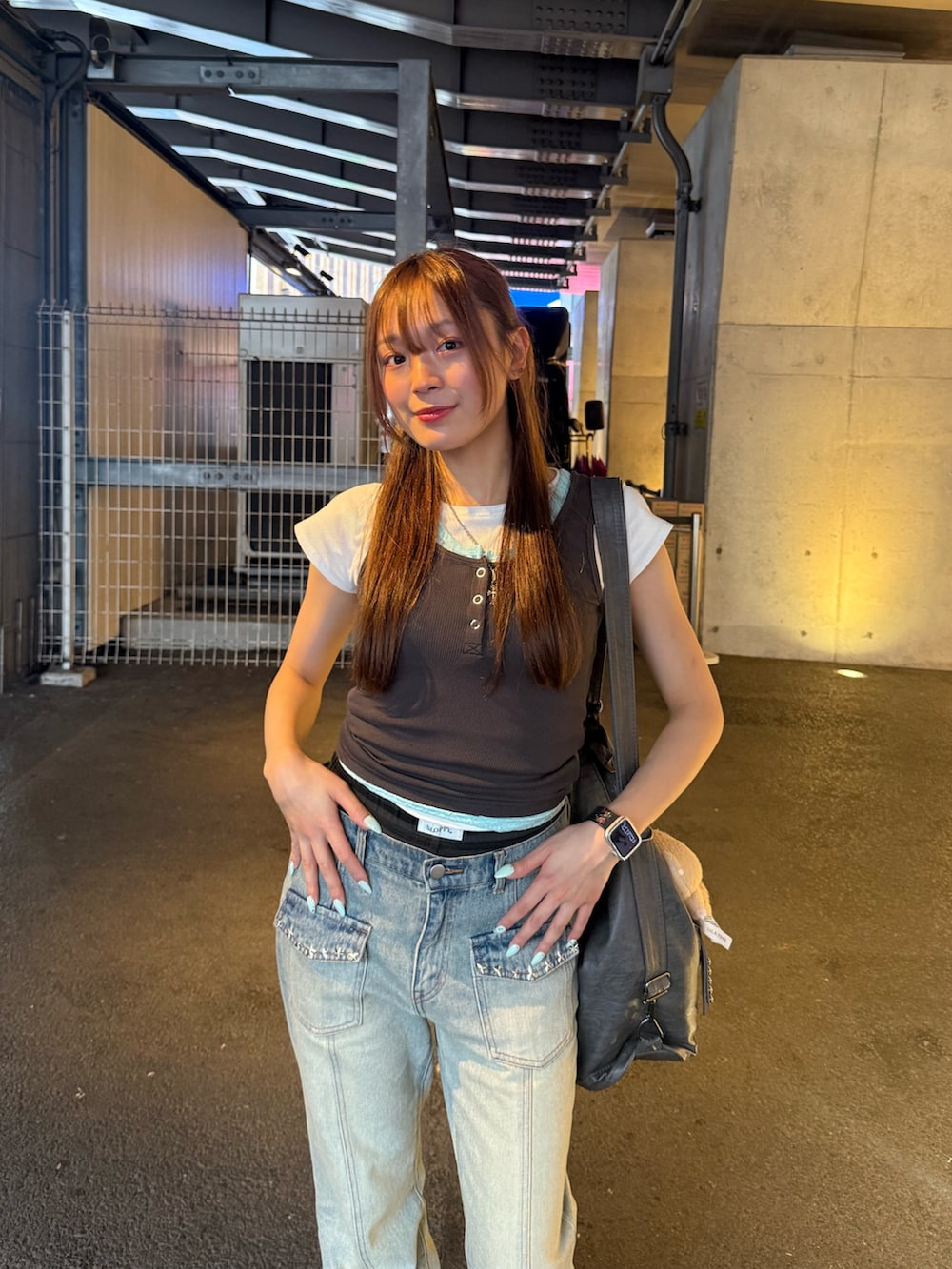 グレー系のタンクトップ、ブルー系のデニムパンツ、グレー系のショルダーバッグを着用したレディースの夏コーディネートの3枚目の写真
