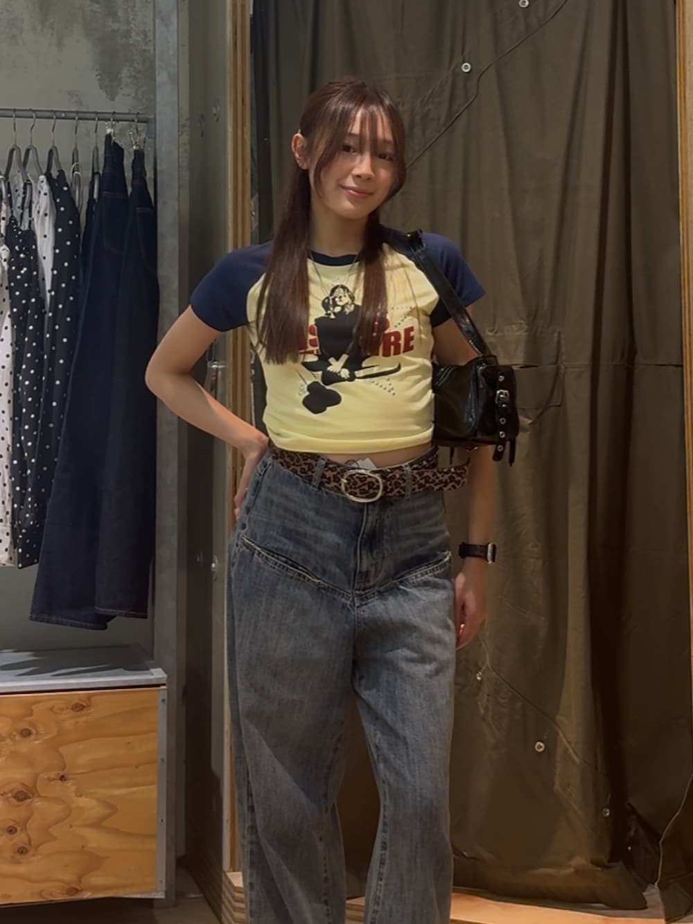 イエロー系のTシャツ/カットソー、ブルー系のデニムパンツ、ブラック系のショルダーバッグを着用したレディースの春コーディネートの2枚目の写真