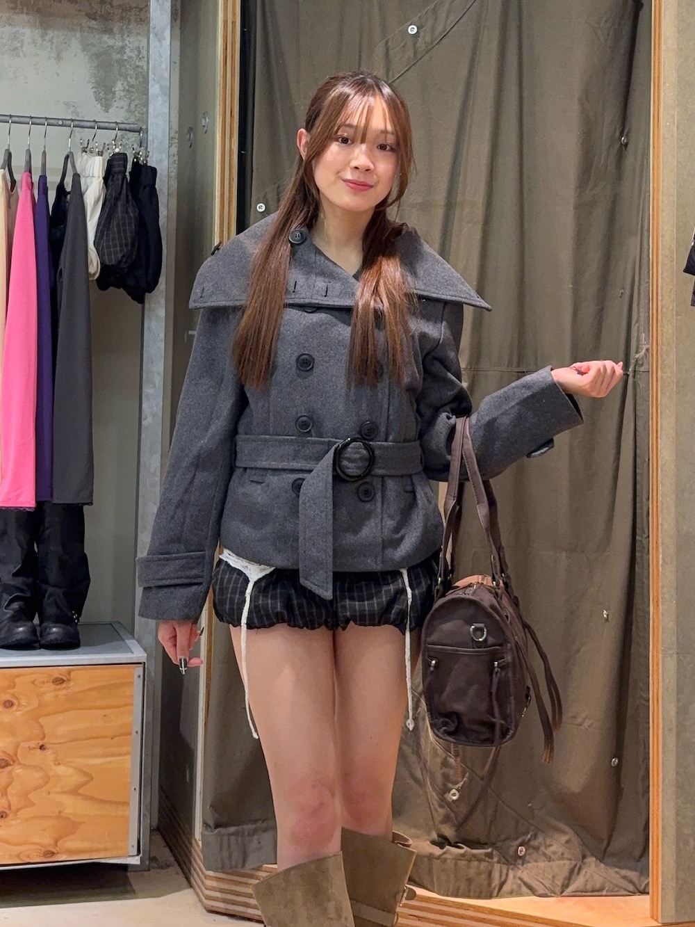 グレー系のピーコート、ホワイト系のキャミソール、ブラウン系のその他パンツを着用したレディースの秋コーディネートの2枚目の写真