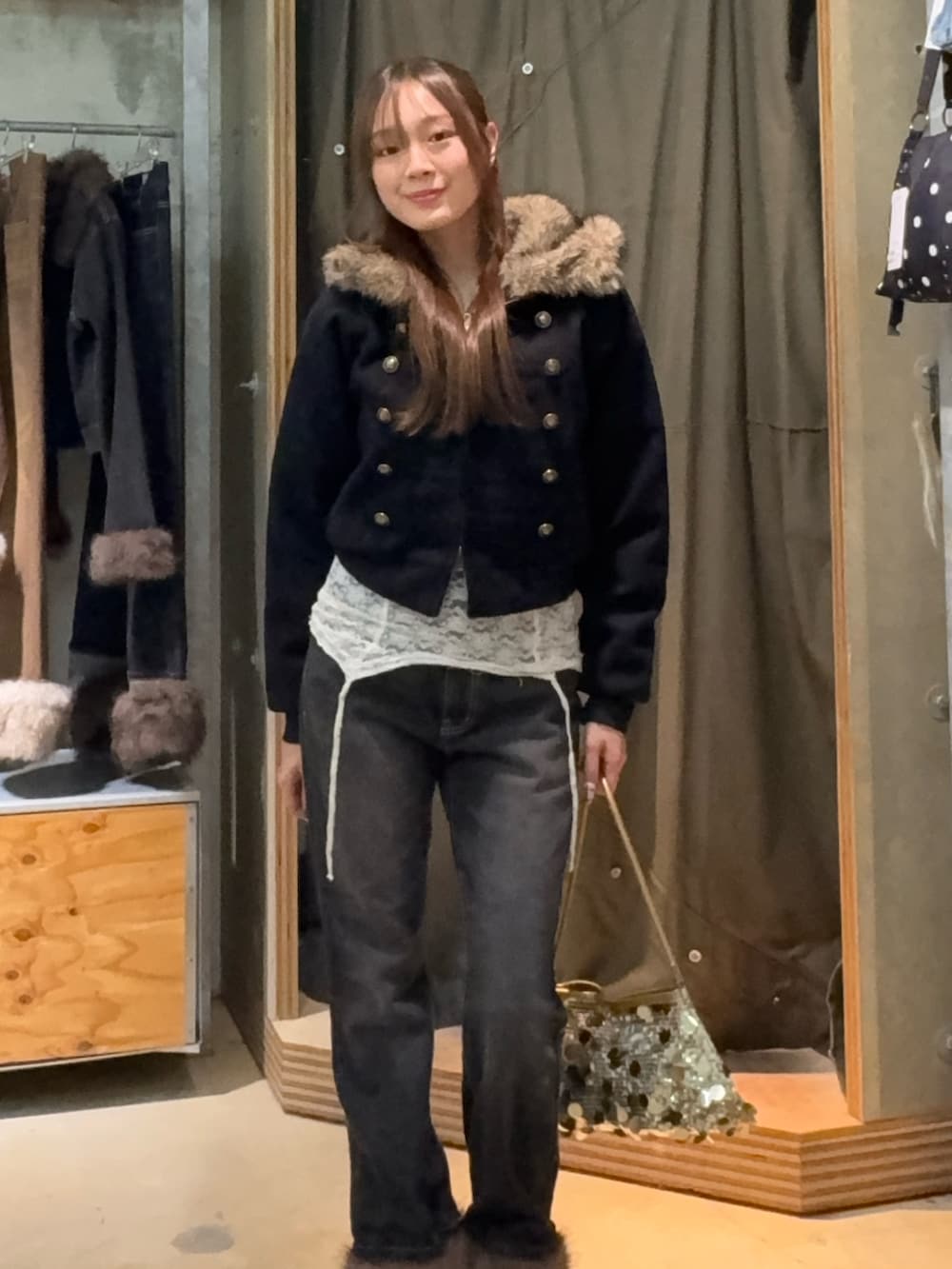 ブルー系のブルゾン、ホワイト系のキャミソール、ブラック系のデニムパンツを着用したレディースの秋コーディネートの2枚目の写真