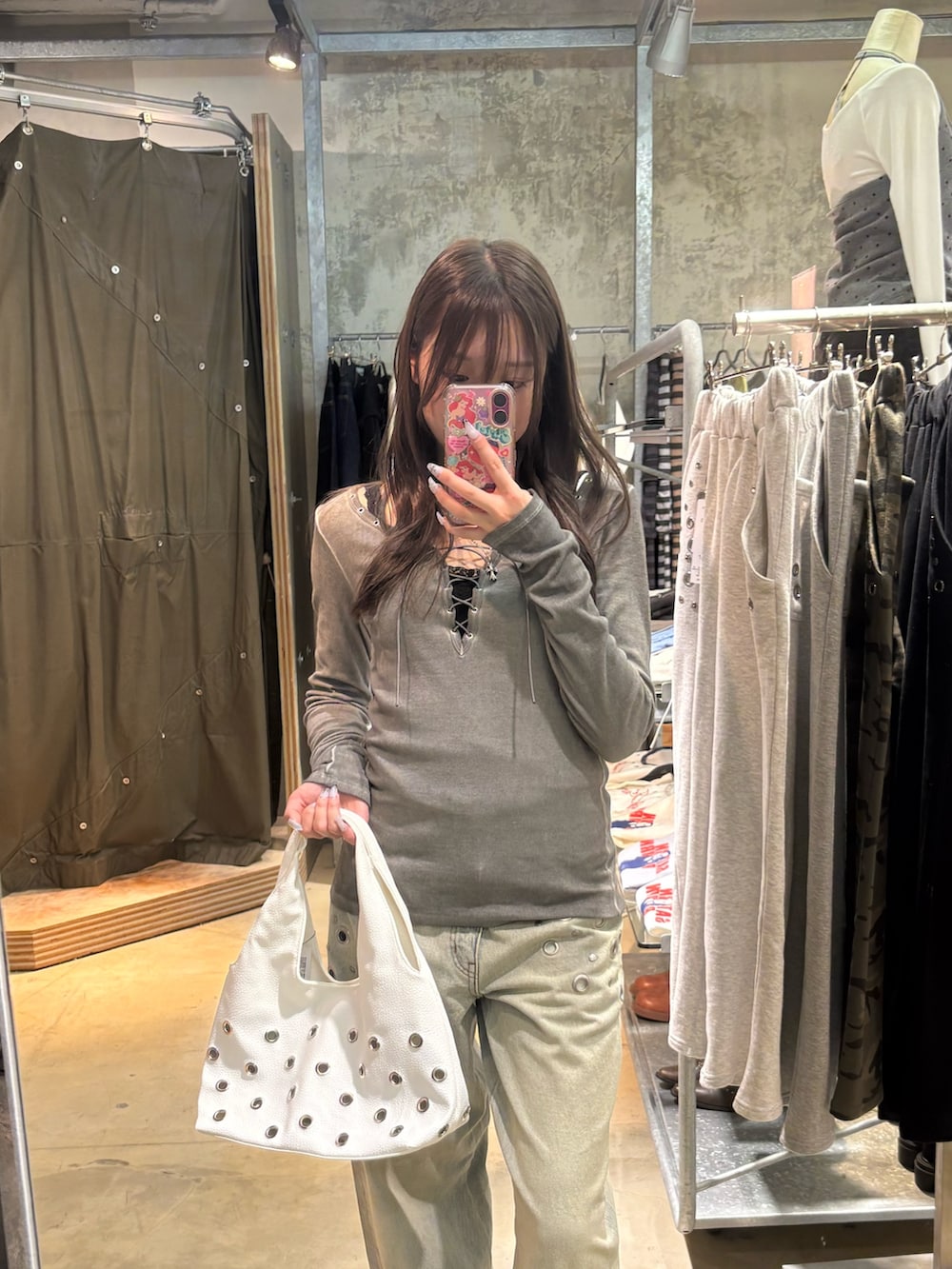 グレー系のTシャツ/カットソー、ブルー系のデニムパンツ、ホワイト系のショルダーバッグを着用したレディースの春コーディネートの2枚目の写真