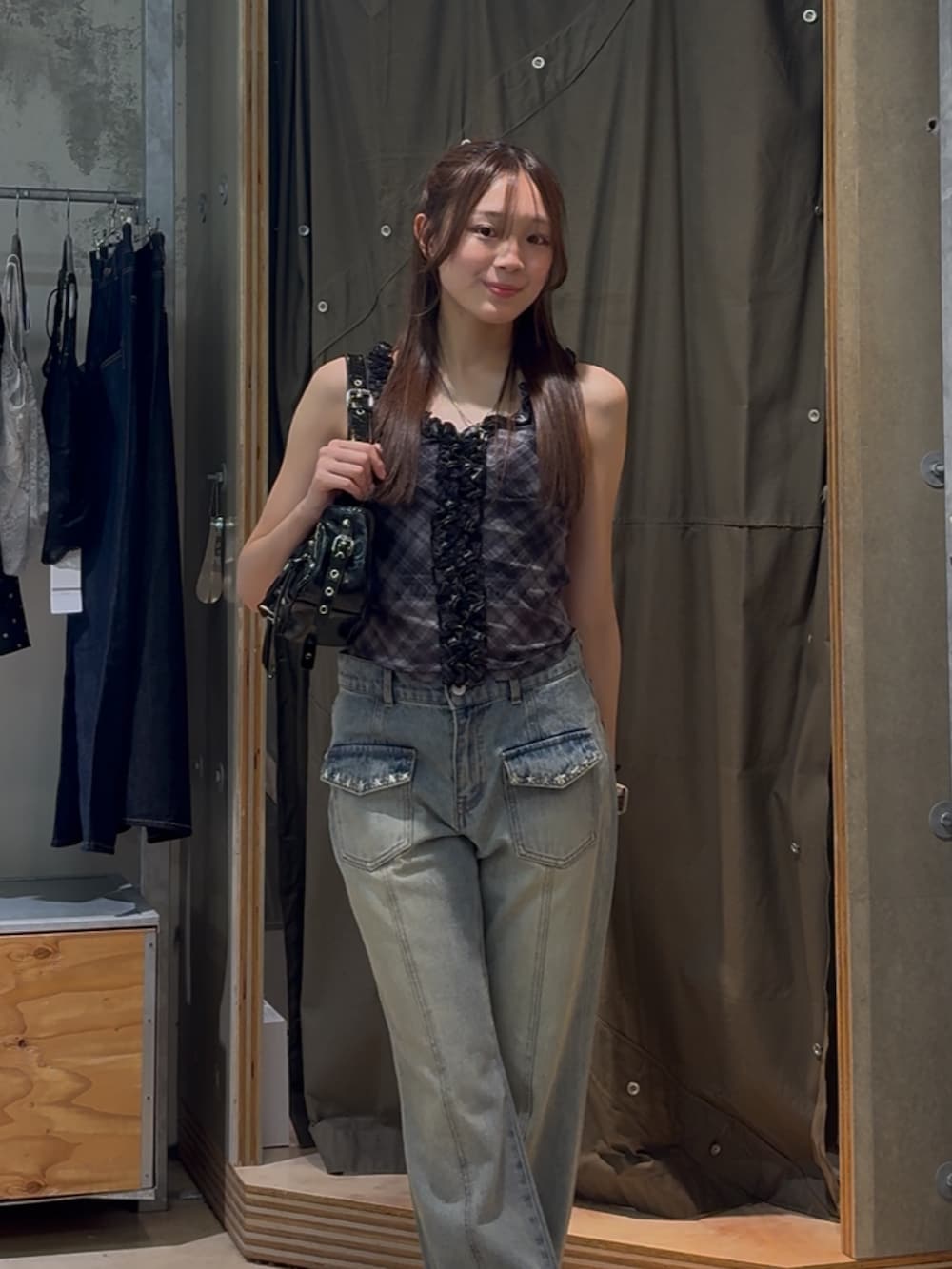 ブラック系のキャミソール、ブルー系のデニムパンツ、ブラック系のショルダーバッグを着用したレディースの春コーディネートの2枚目の写真