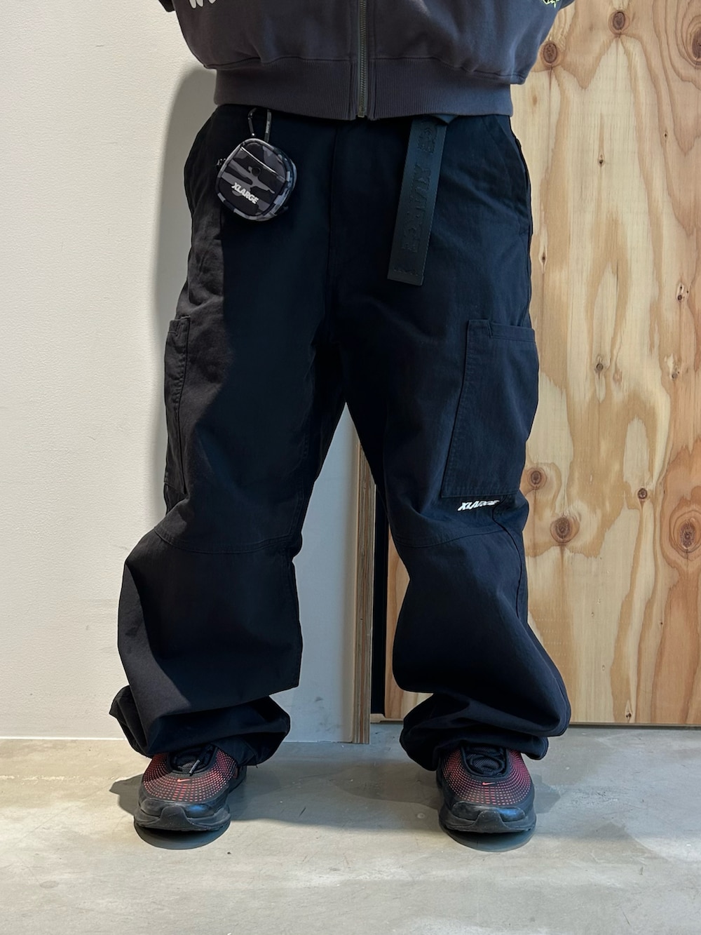 グレー系のパーカー、ブラック系のカーゴパンツ、ブラック系のスニーカーを着用したメンズの春コーディネートの4枚目の写真