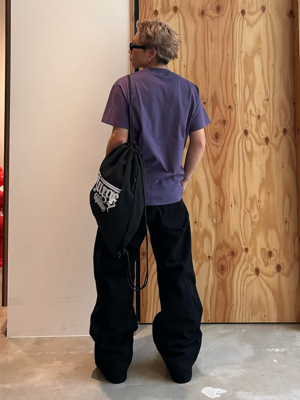 パープル系のTシャツ/カットソー、ブラック系のその他パンツ、ブラック系のバックパック/リュックを着用したメンズの夏コーディネートの2枚目の写真