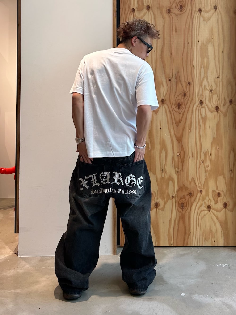 ホワイト系のTシャツ/カットソー、ブラック系のデニムパンツ、ブラック系のサングラスを着用したメンズの夏コーディネートの2枚目の写真