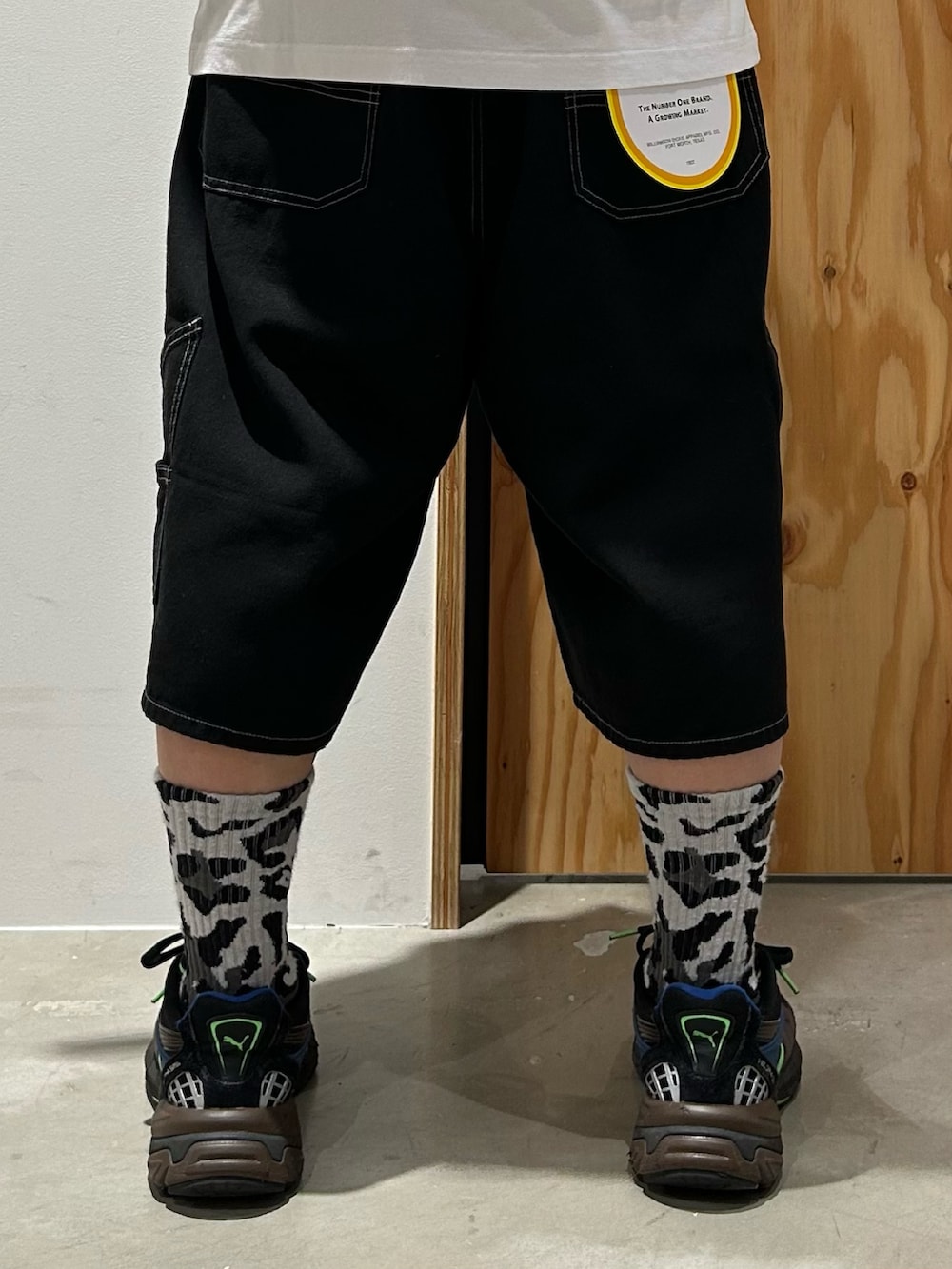 ホワイト系のTシャツ/カットソー、ブラック系のデニムパンツ、ブラック系のスニーカーを着用したメンズの夏コーディネートの6枚目の写真