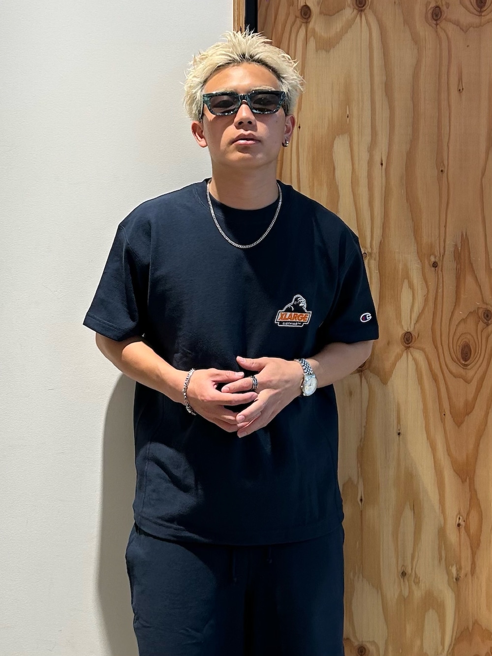 ブルー系のTシャツ/カットソー、ブルー系のスウェットパンツ、グリーン系のサングラスを着用したメンズの春コーディネートの4枚目の写真