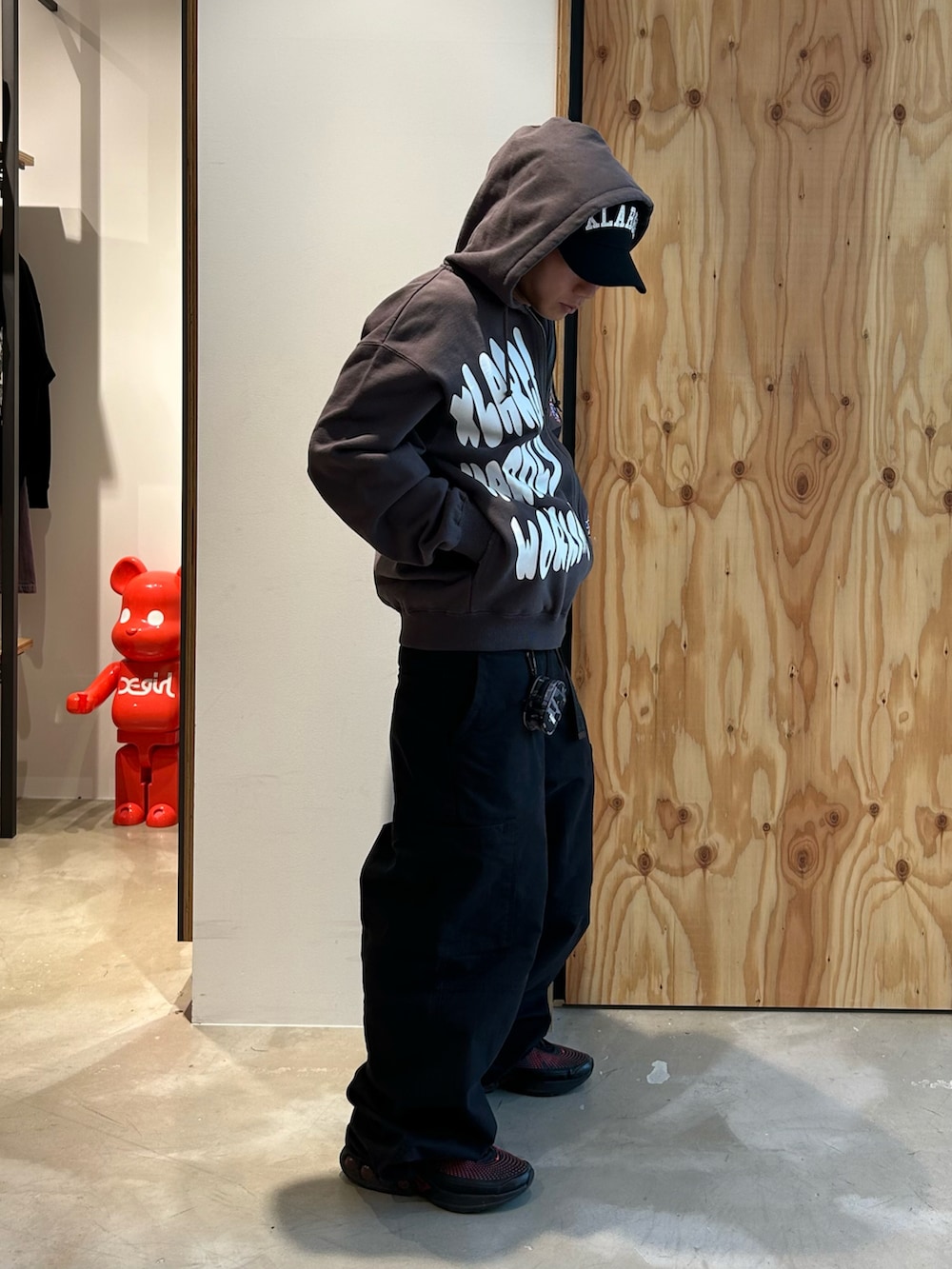 グレー系のパーカー、ブラック系のカーゴパンツ、ブラック系のスニーカーを着用したメンズの春コーディネートの2枚目の写真