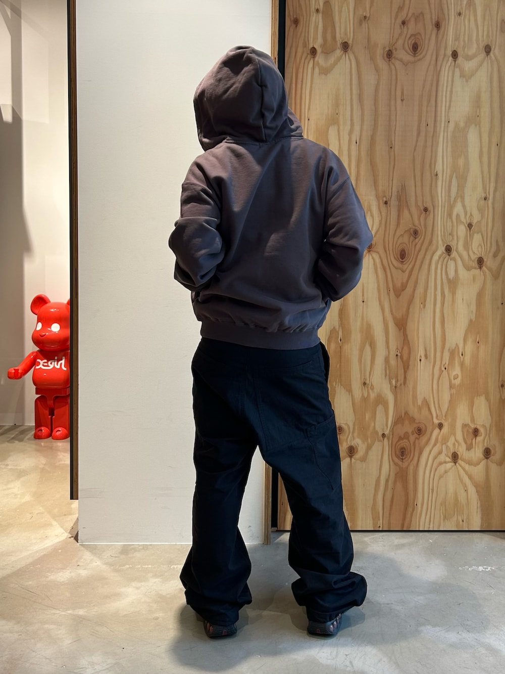 グレー系のパーカー、ブラック系のカーゴパンツ、ブラック系のスニーカーを着用したメンズの春コーディネートの3枚目の写真