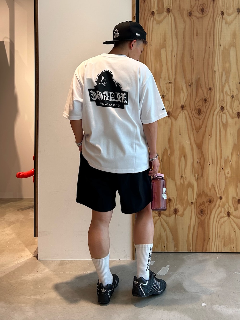 ホワイト系のTシャツ/カットソー、ブラック系のその他パンツ、ブラック系のキャップを着用したメンズの夏コーディネートの2枚目の写真