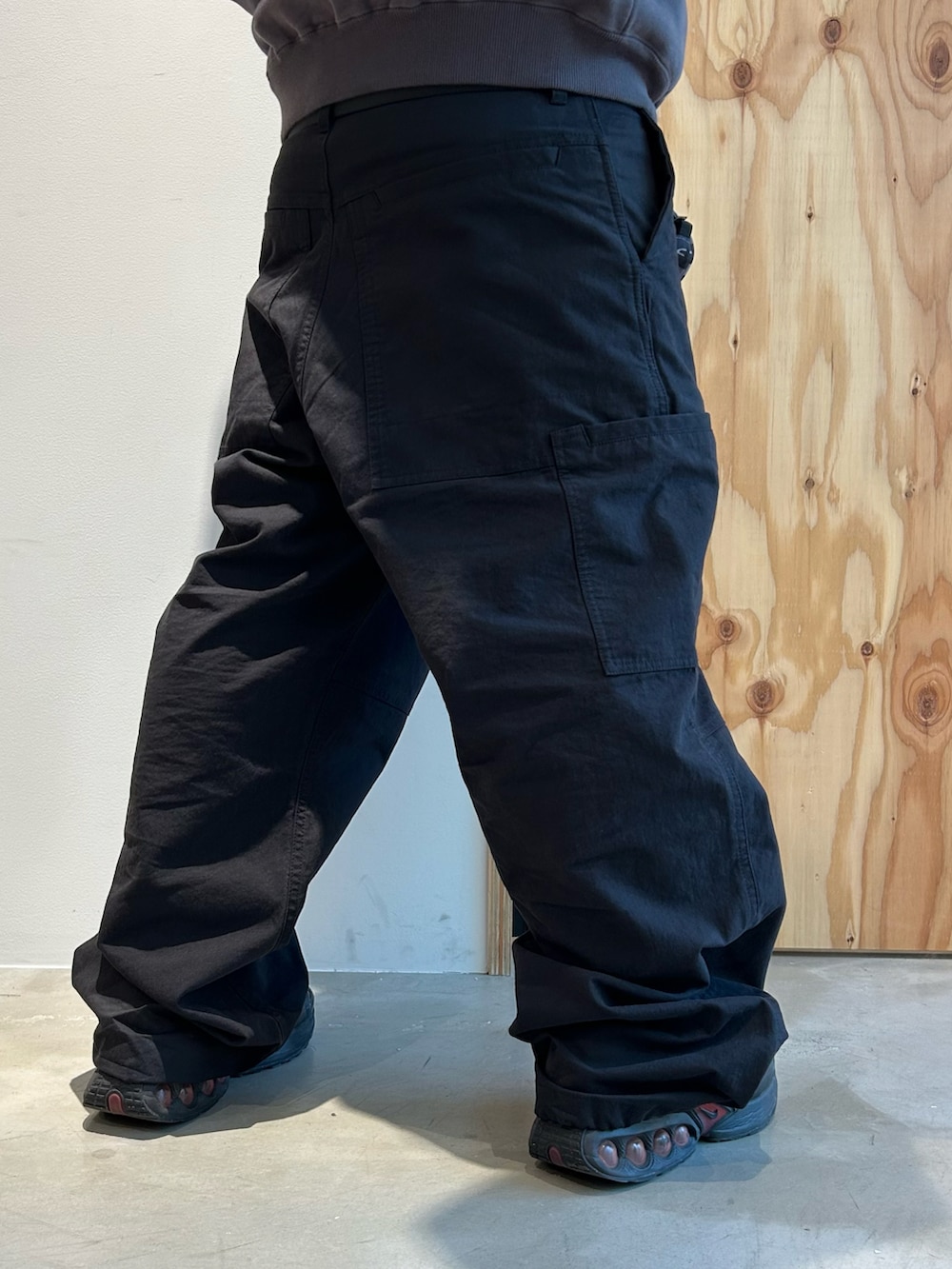 グレー系のパーカー、ブラック系のカーゴパンツ、ブラック系のスニーカーを着用したメンズの春コーディネートの5枚目の写真