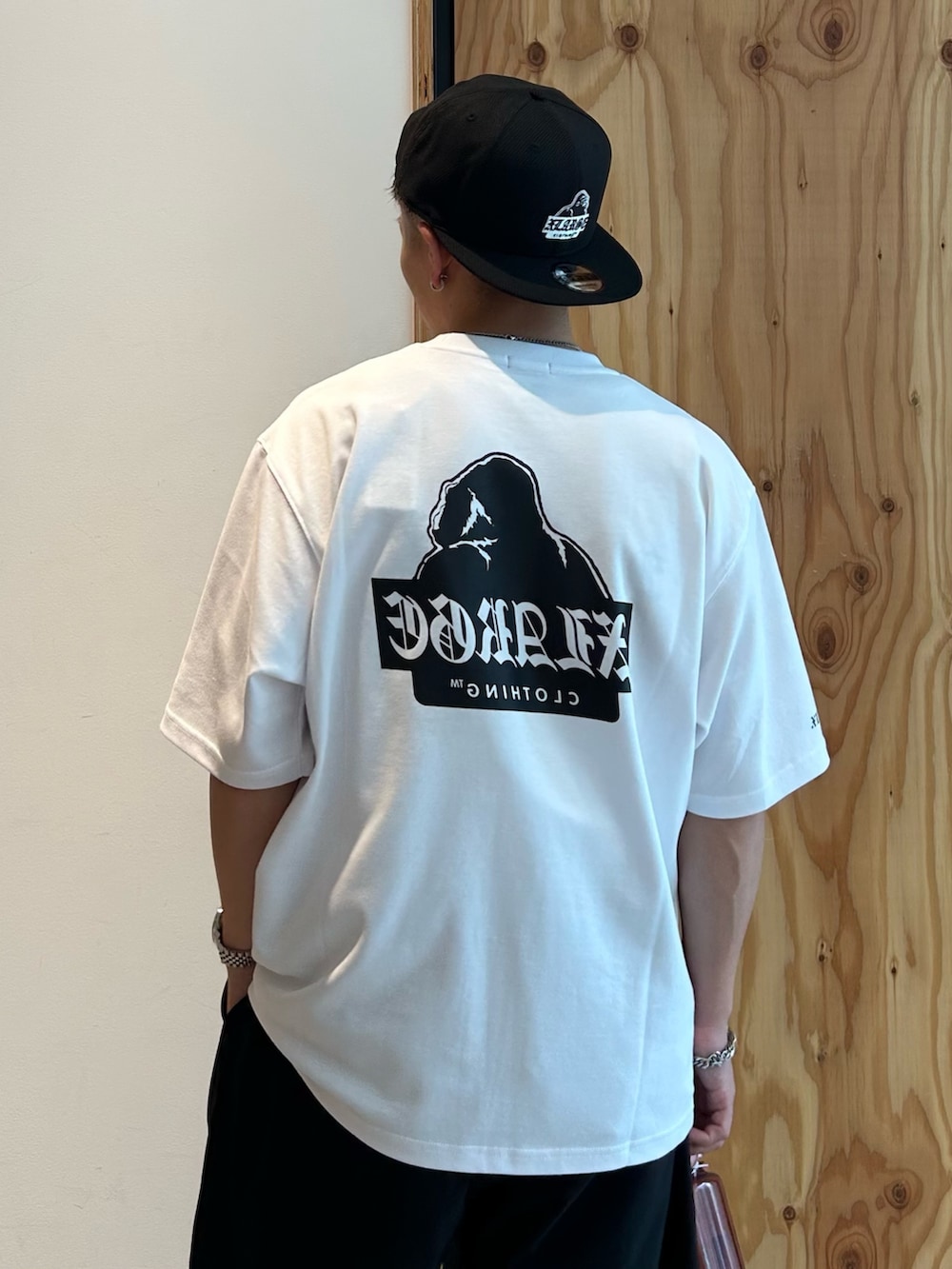ホワイト系のTシャツ/カットソー、ブラック系のその他パンツ、ブラック系のキャップを着用したメンズの夏コーディネートの4枚目の写真