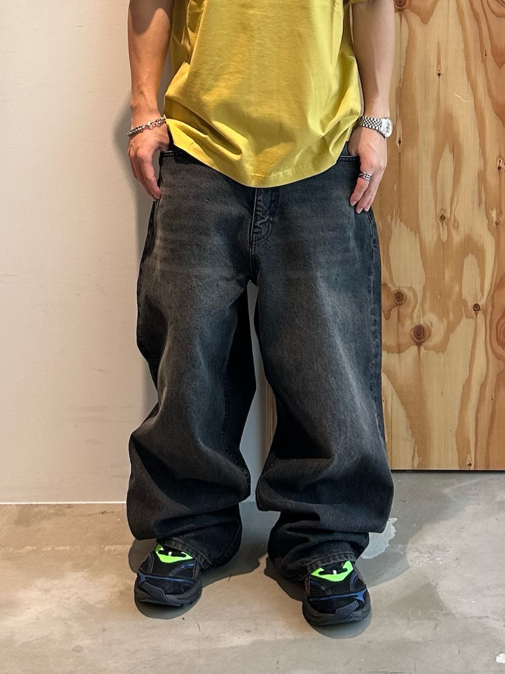 イエロー系のTシャツ/カットソー、ブラック系のデニムパンツ、ブラウン系のサングラスを着用したメンズの夏コーディネートの4枚目の写真