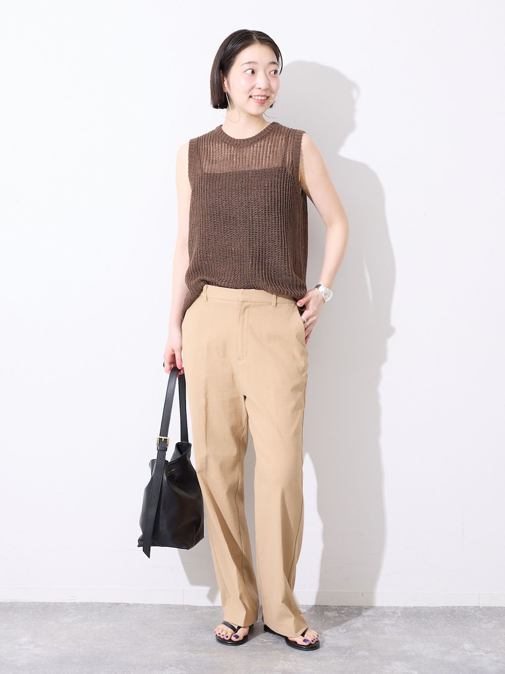 ベージュ系のその他パンツ、ブラウン系のニット/セーター、ブラック系のサンダルを着用したレディースの春コーディネートの2枚目の写真