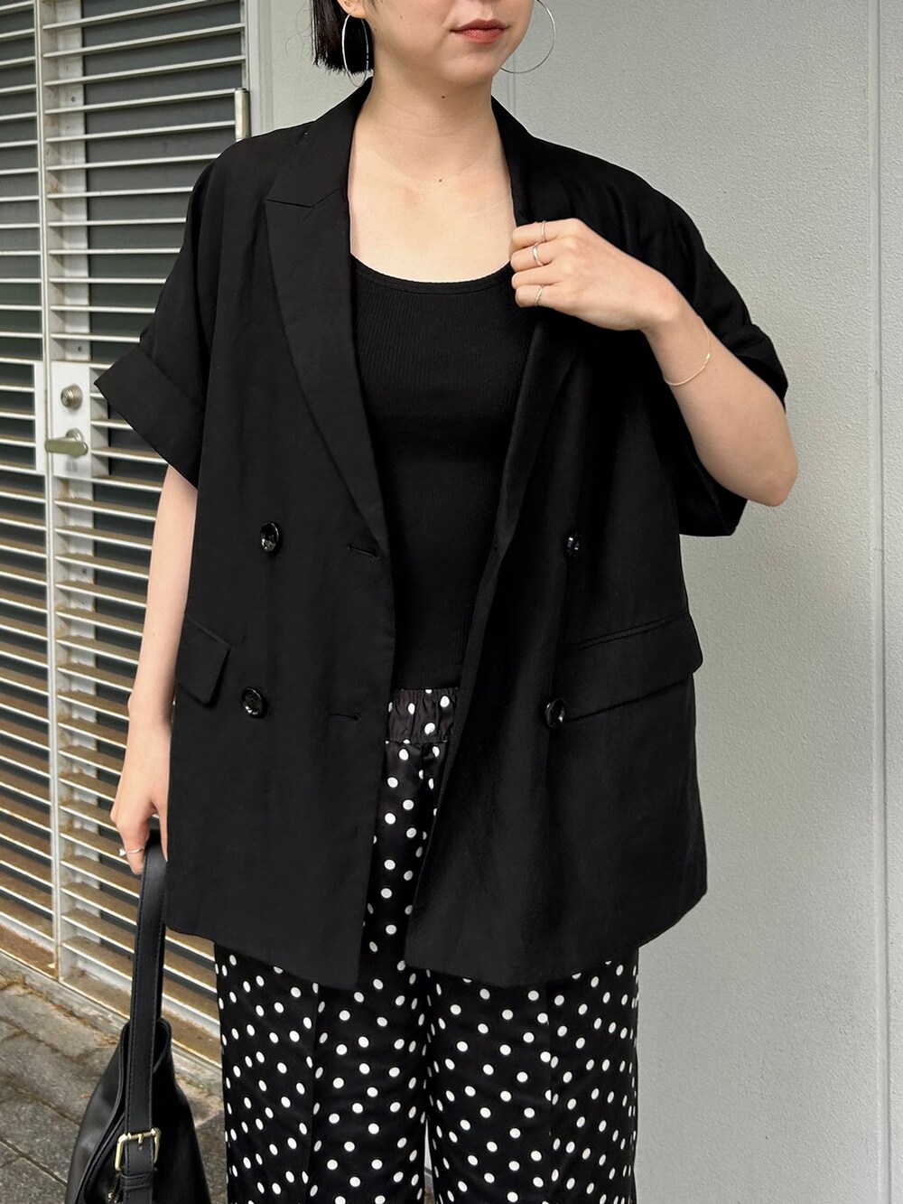 ブラック系のその他アウター、ブラック系のその他パンツ、ブラック系のショルダーバッグを着用したレディースの夏コーディネートの6枚目の写真