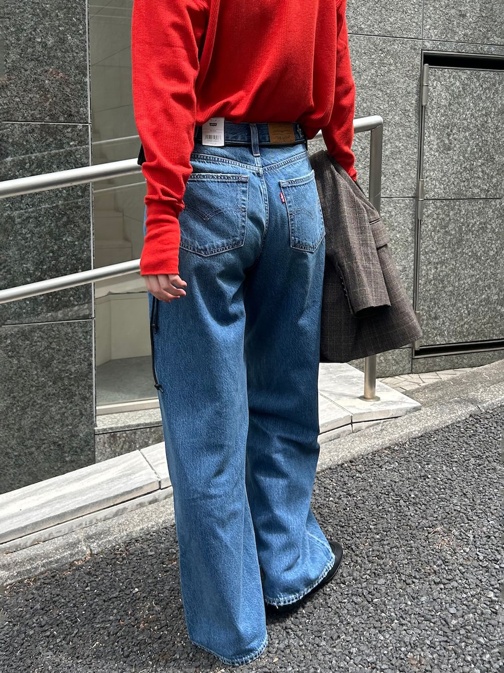 ブラウン系のテーラードジャケット、ブルー系のデニムパンツ、レッド系のTシャツ/カットソーを着用したレディースの夏コーディネートの6枚目の写真