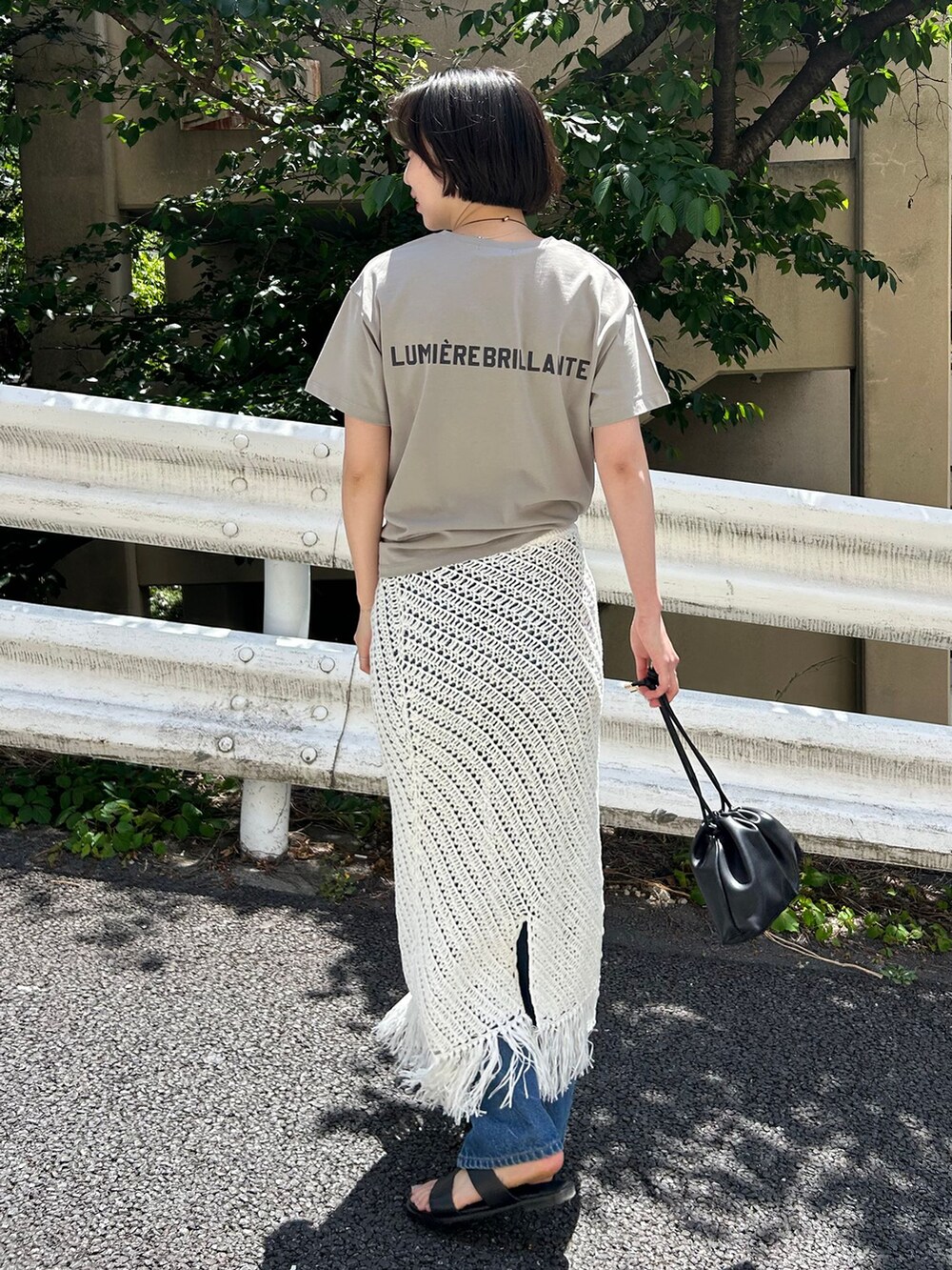 ブルー系のデニムパンツ、ホワイト系のスカート、グリーン系のTシャツ/カットソーを着用したレディースの春コーディネートの3枚目の写真
