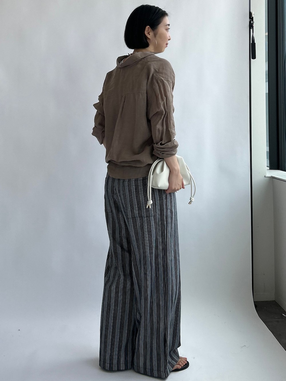 ブラック系のその他パンツ、ベージュ系のシャツ/ブラウス、ホワイト系のタンクトップを着用したレディースの夏コーディネートの3枚目の写真