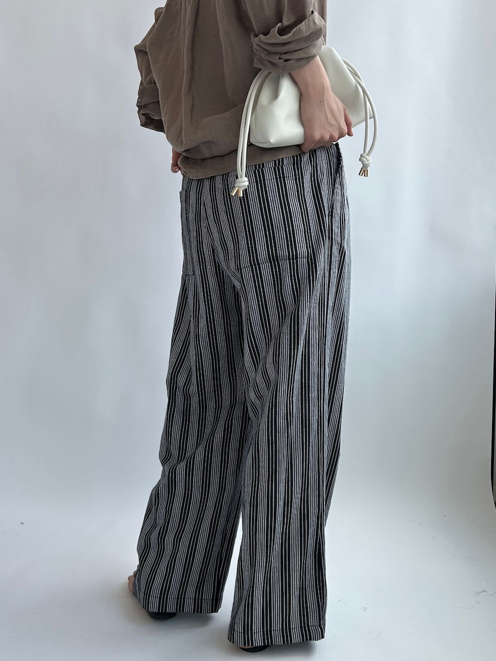 ブラック系のその他パンツ、ベージュ系のシャツ/ブラウス、ホワイト系のタンクトップを着用したレディースの夏コーディネートの8枚目の写真
