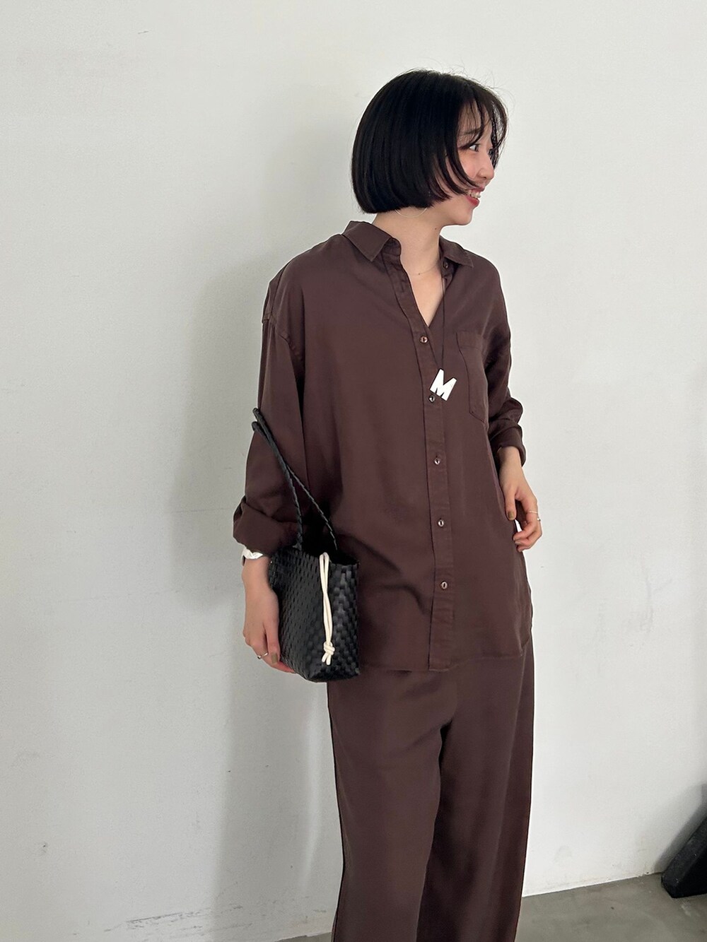 ブラウン系のその他パンツ、ブラウン系のシャツ/ブラウス、ブラック系のかごバッグを着用したレディースの夏コーディネートの2枚目の写真