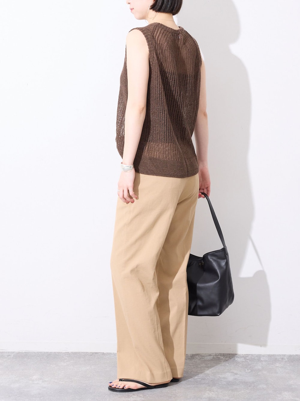 ベージュ系のその他パンツ、ブラウン系のニット/セーター、ブラック系のサンダルを着用したレディースの春コーディネートの4枚目の写真