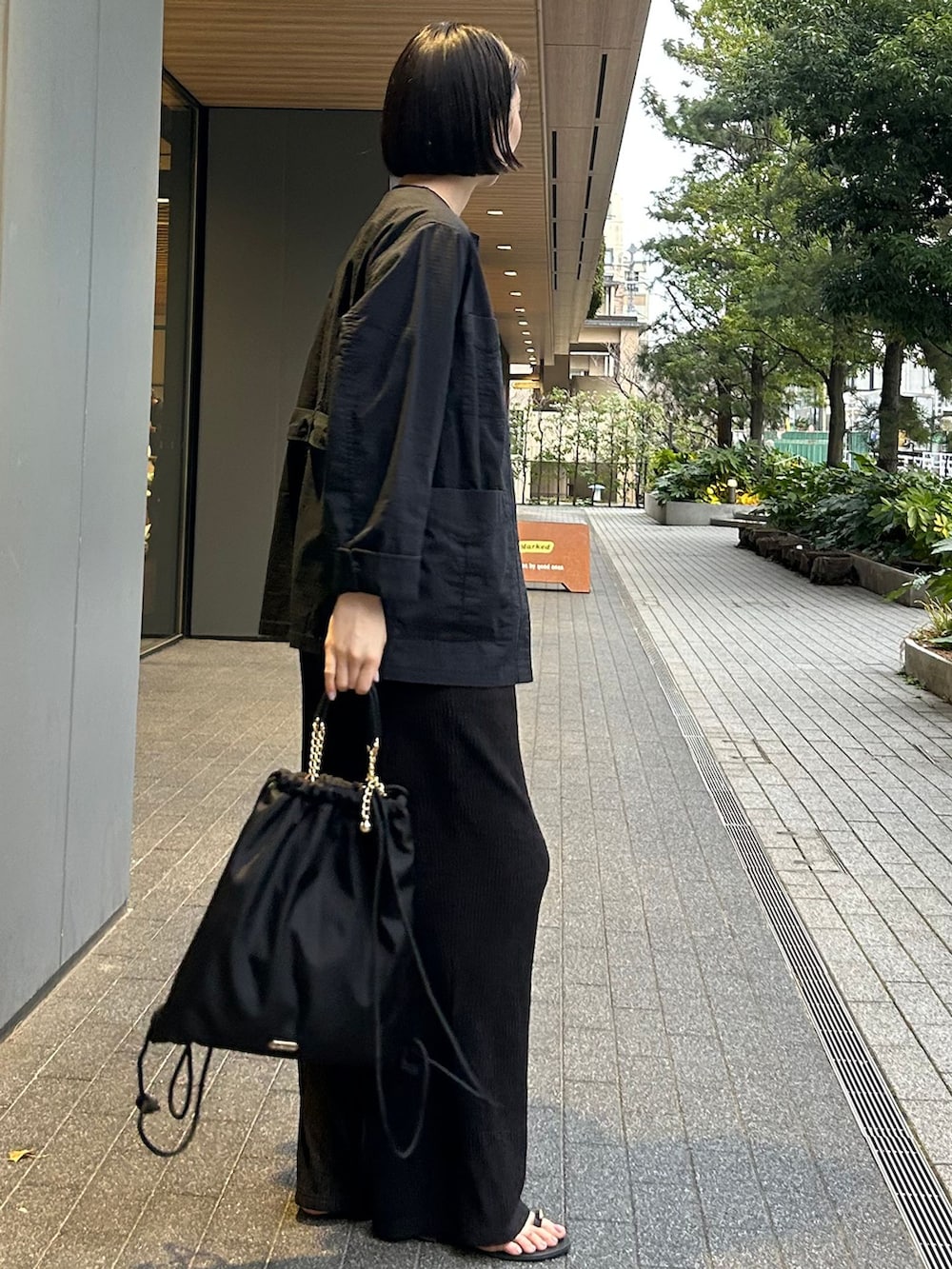 ブラック系のその他アウター、ブラック系のその他パンツ、ブラック系のバックパック/リュックを着用したレディースの春コーディネートの3枚目の写真