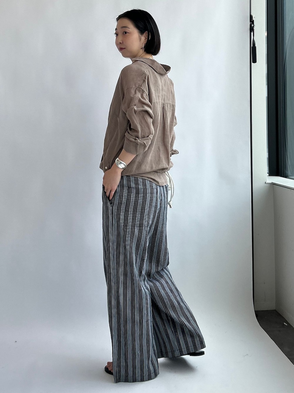 ブラック系のその他パンツ、ベージュ系のシャツ/ブラウス、ホワイト系のタンクトップを着用したレディースの夏コーディネートの2枚目の写真