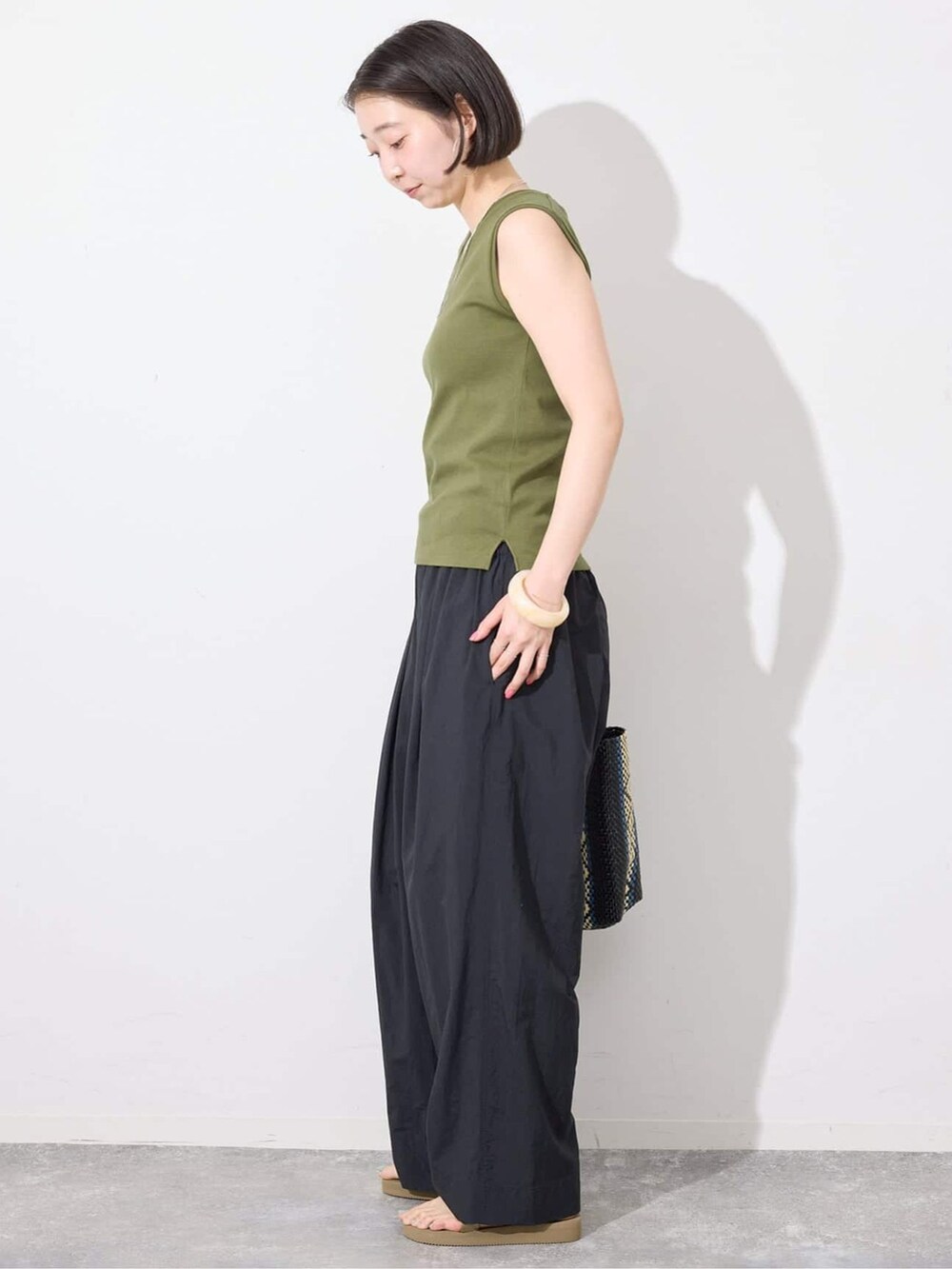 ブラック系のその他パンツ、グリーン系のTシャツ/カットソー、ブルー系のトートバッグを着用したレディースの夏コーディネートの2枚目の写真