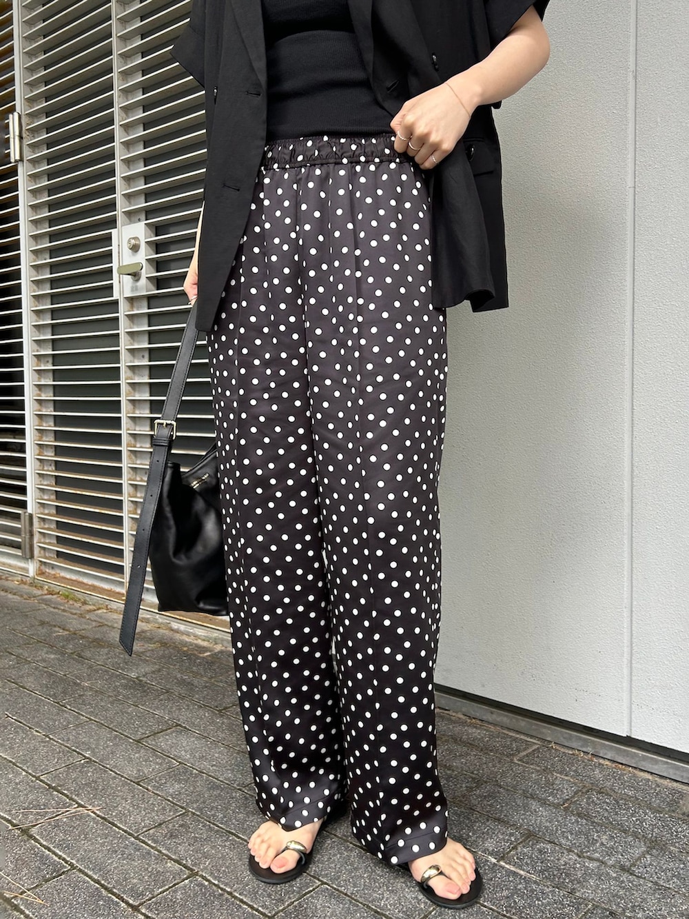 ブラック系のその他アウター、ブラック系のその他パンツ、ブラック系のショルダーバッグを着用したレディースの夏コーディネートの4枚目の写真