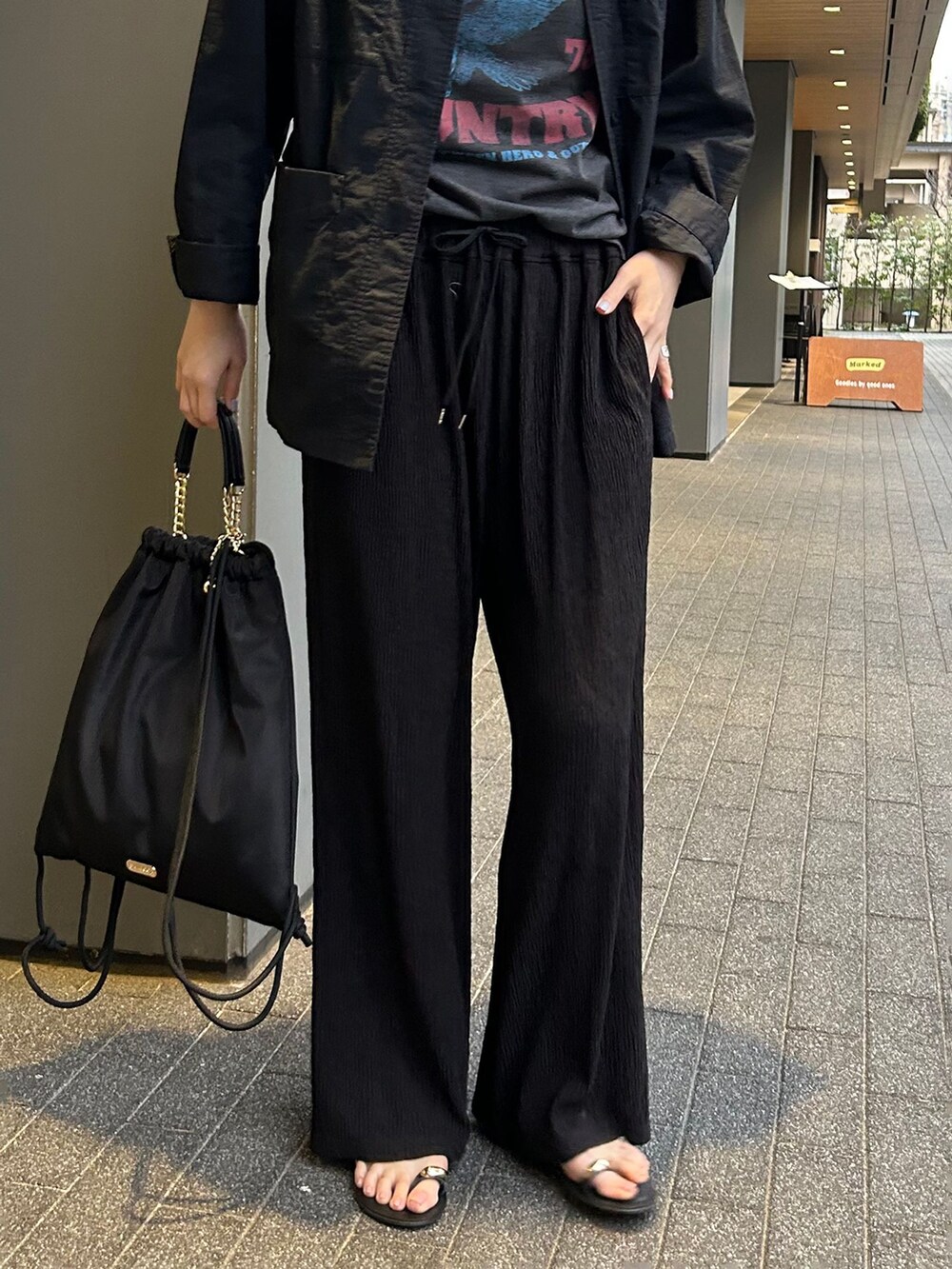 ブラック系のその他アウター、ブラック系のその他パンツ、ブラック系のバックパック/リュックを着用したレディースの春コーディネートの6枚目の写真