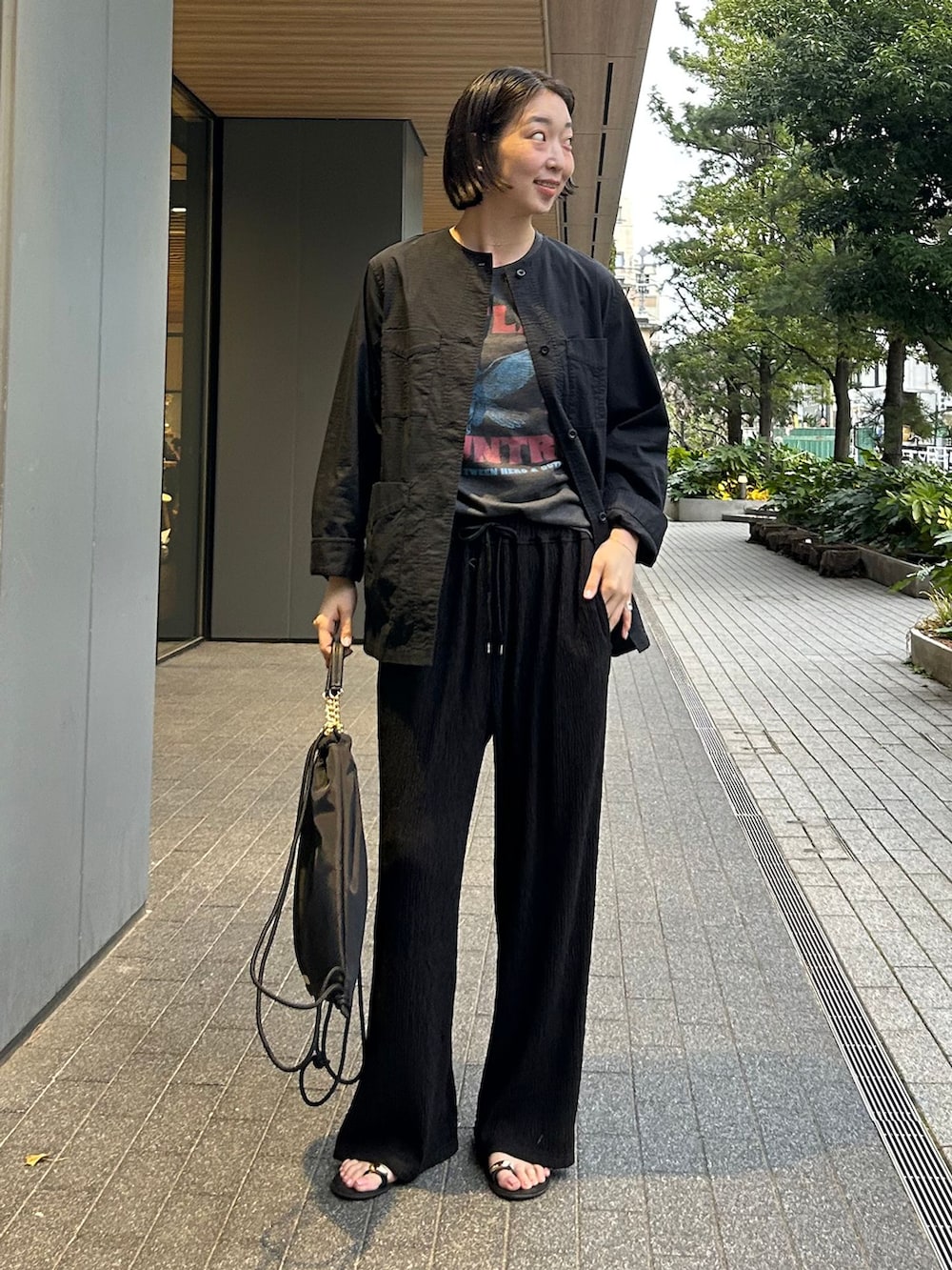 ブラック系のその他アウター、ブラック系のその他パンツ、ブラック系のバックパック/リュックを着用したレディースの春コーディネートの2枚目の写真